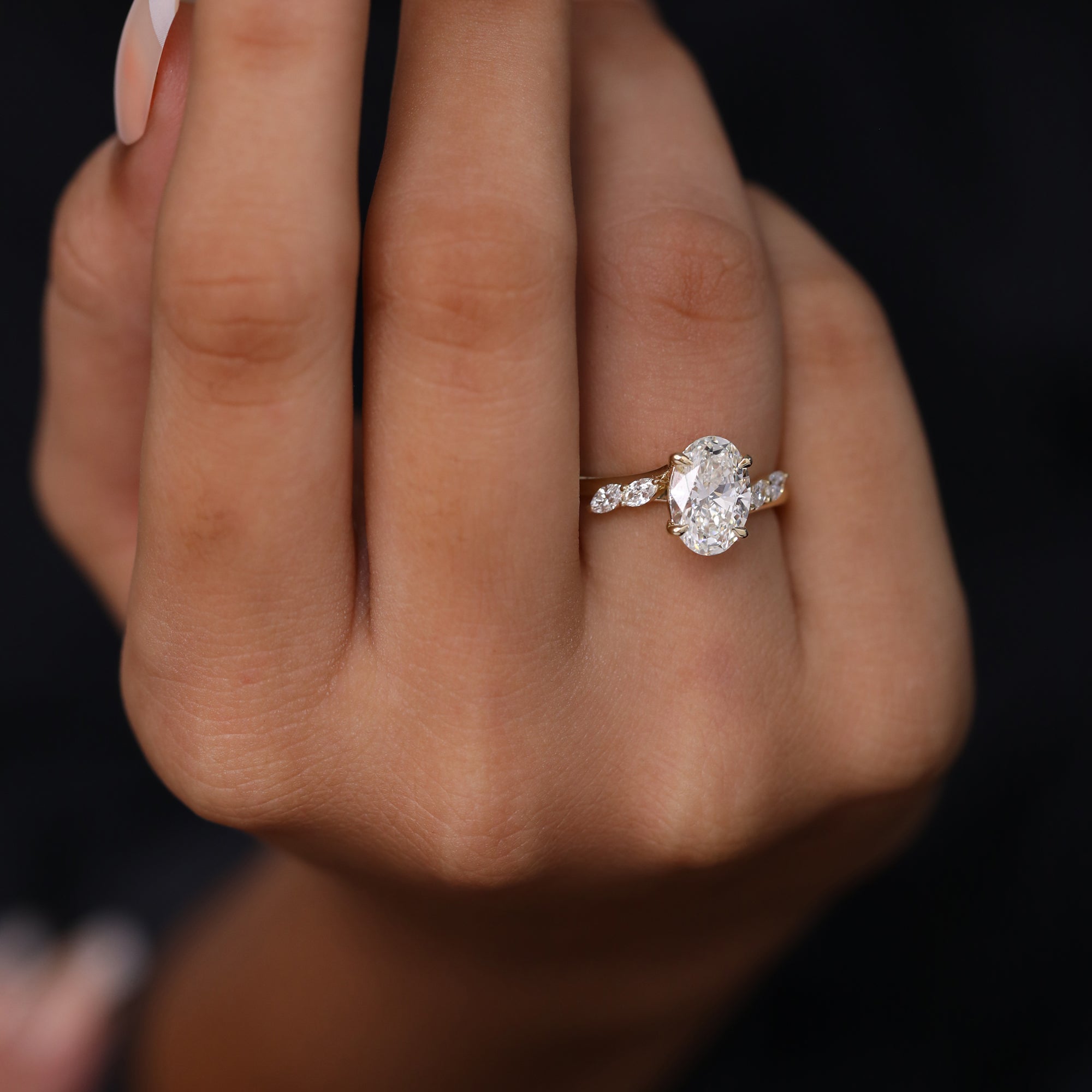 Luxury yellow gold oval diamond engagement ring with marquise cluster accents