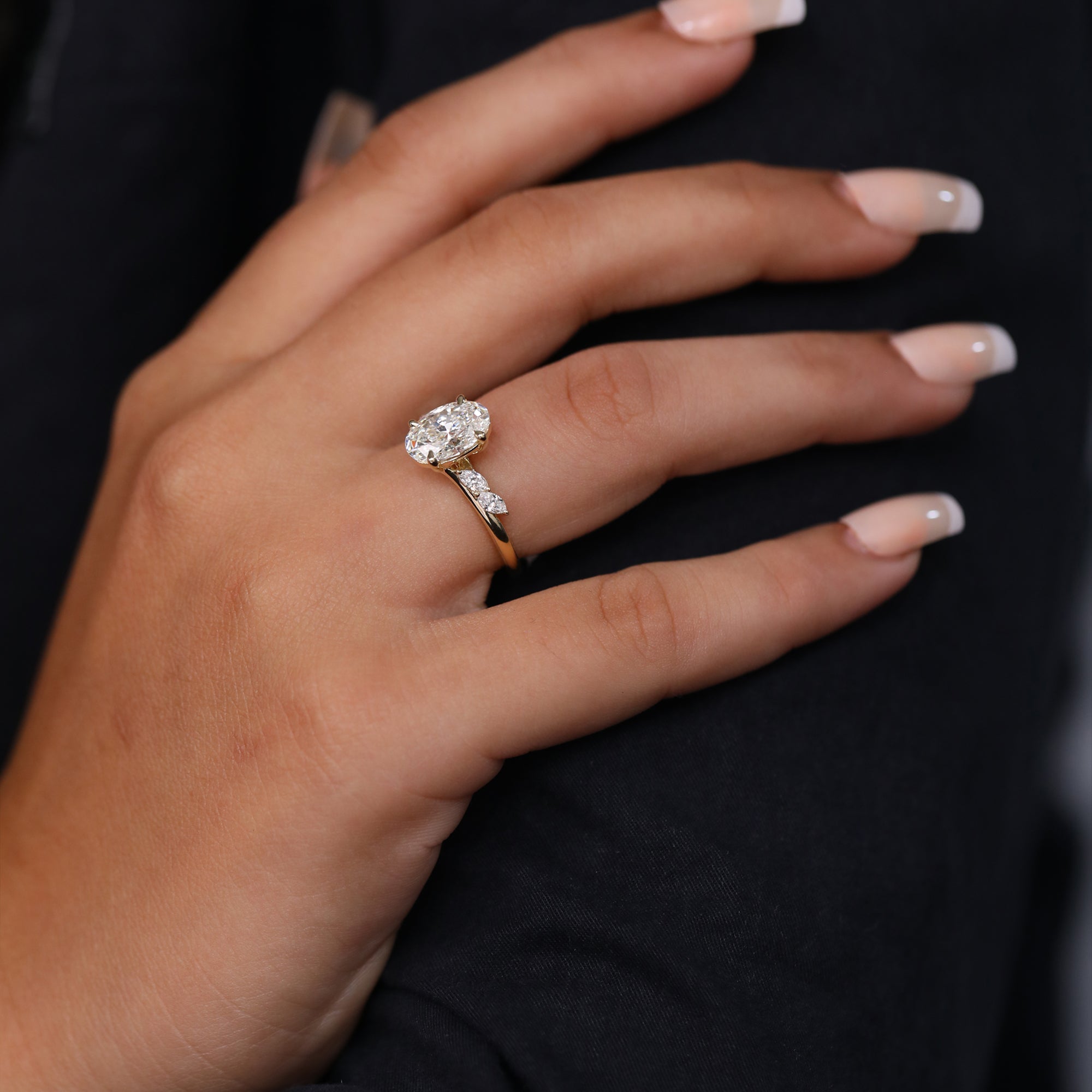 Bridal oval diamond engagement ring featuring marquise diamond accents