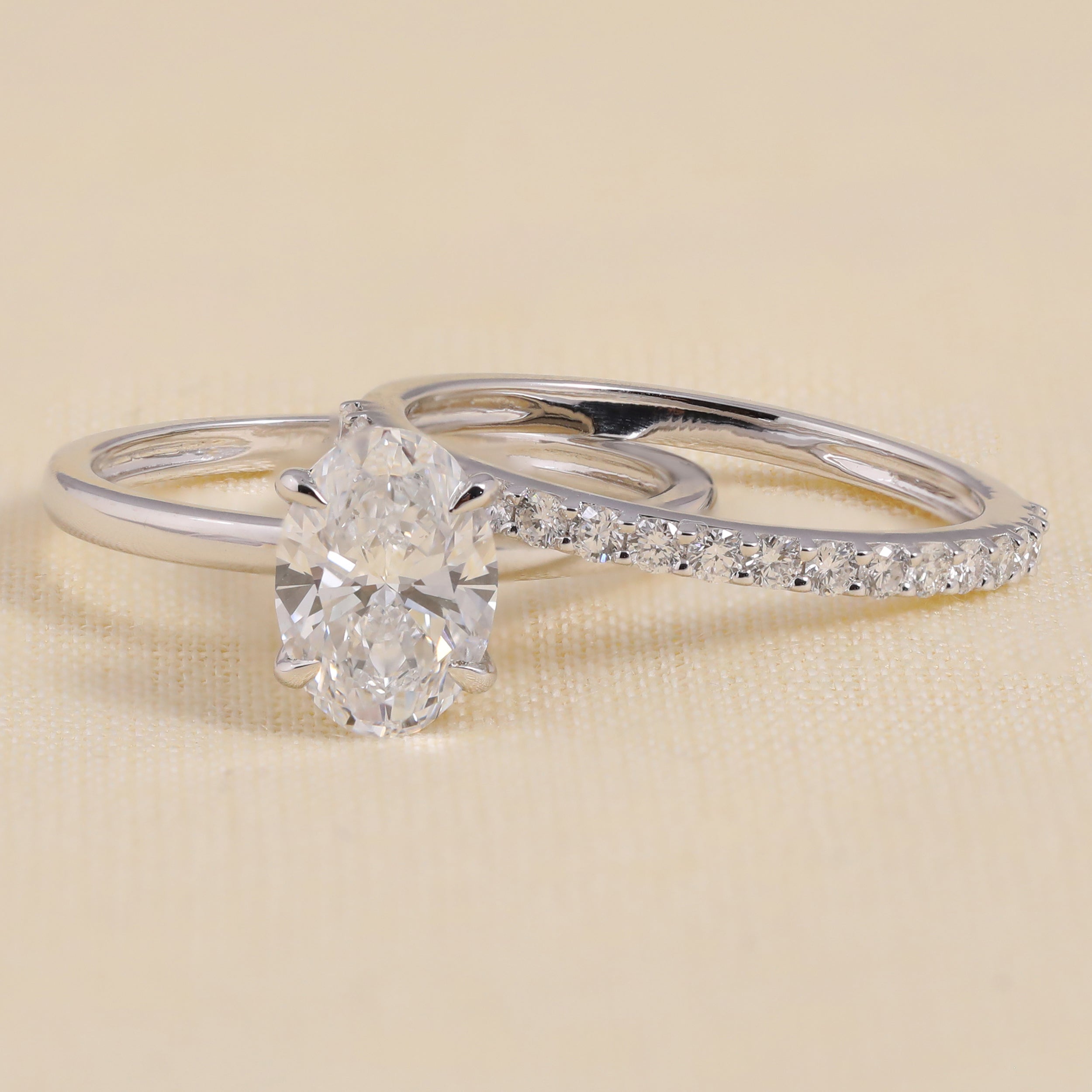 Bridal ring set featuring an oval-cut solitaire engagement ring and pavé band