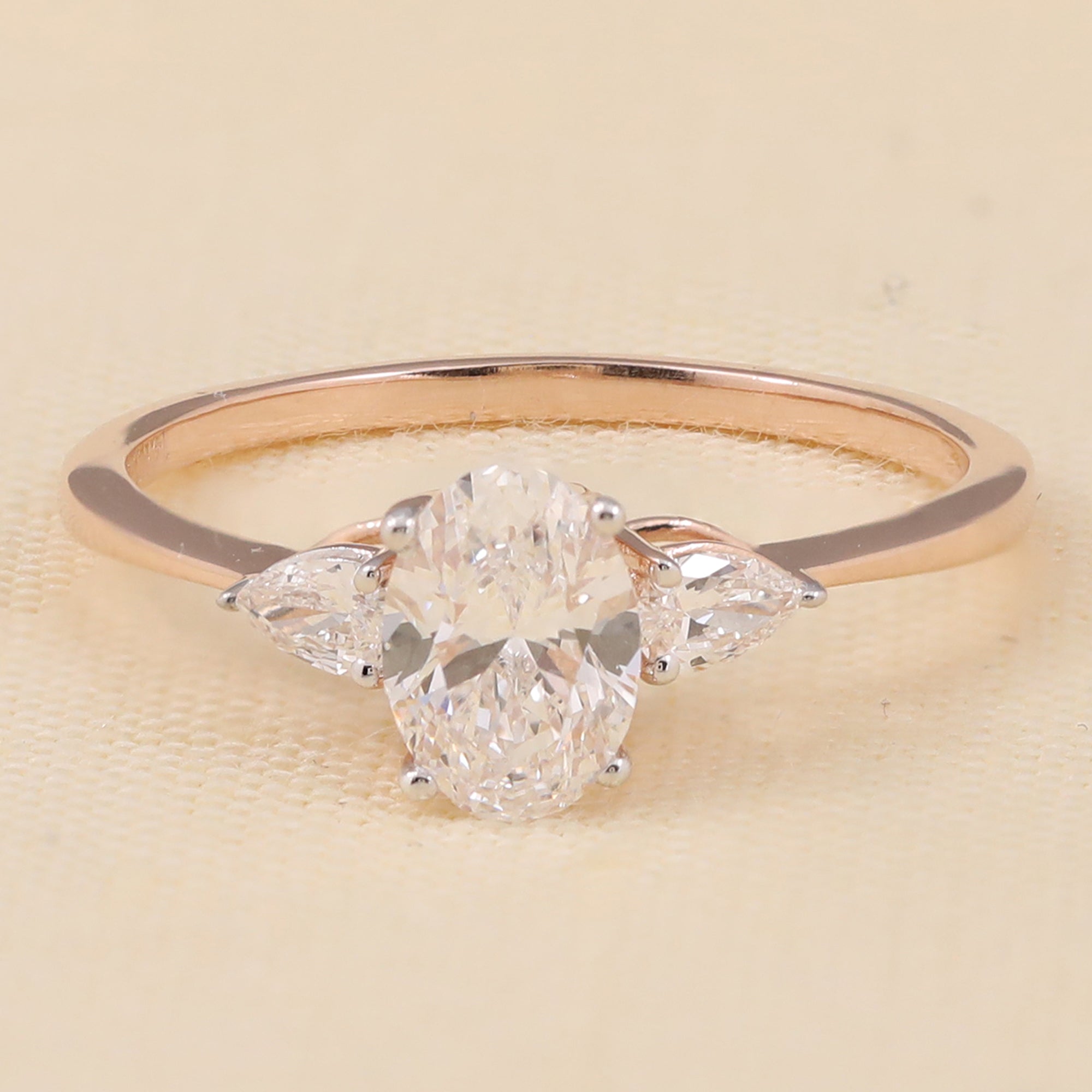 Oval lab diamond engagement ring with two pear-shaped side stones for an elegant three-stone look