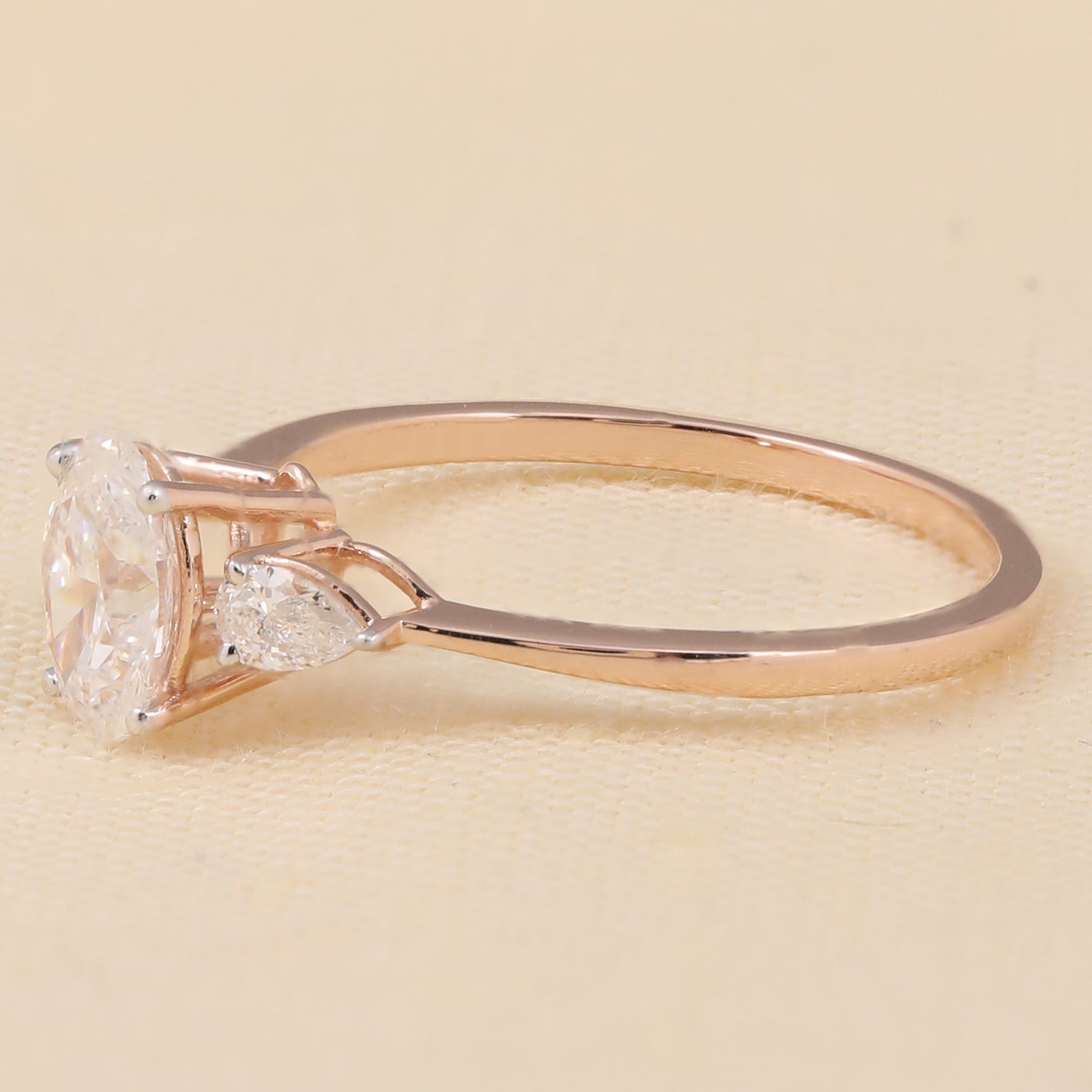 Three-stone lab-grown diamond ring featuring an oval center and pear-cut accents