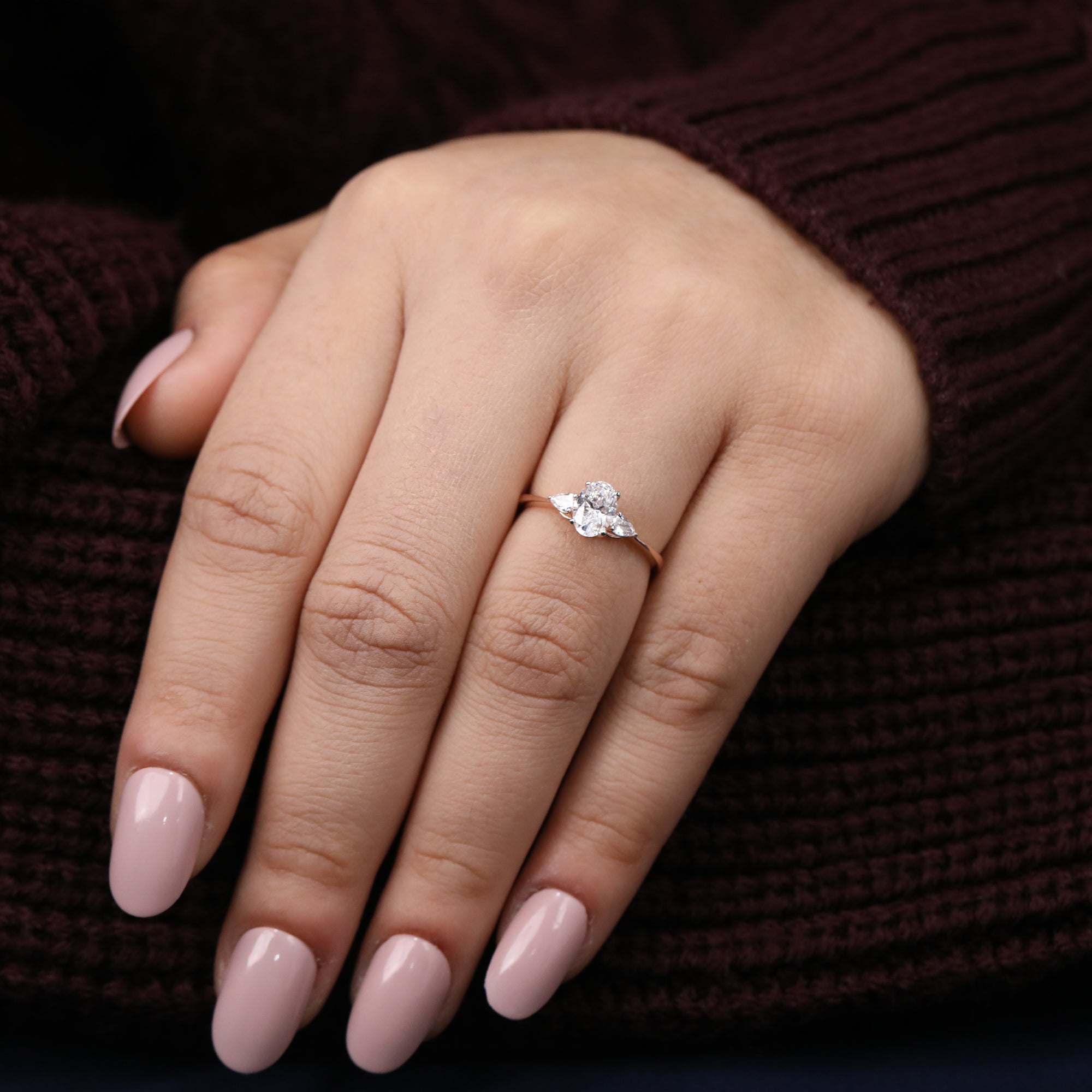 Luxurious three-stone lab diamond ring with an oval centerpiece and pear side accents