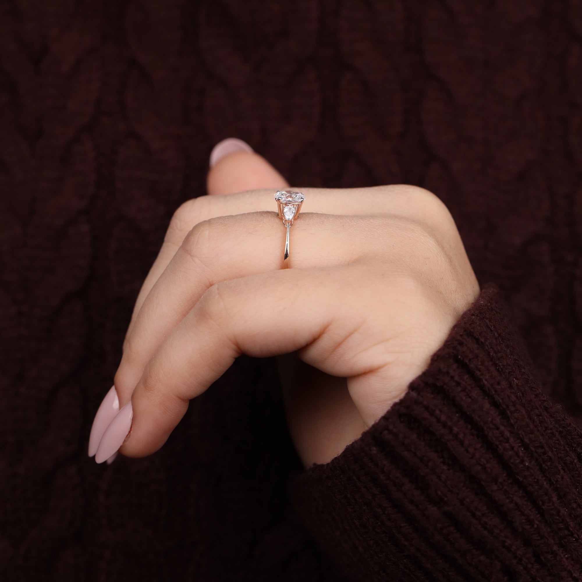 Minimalist engagement ring with an oval lab diamond and pear cut side stones