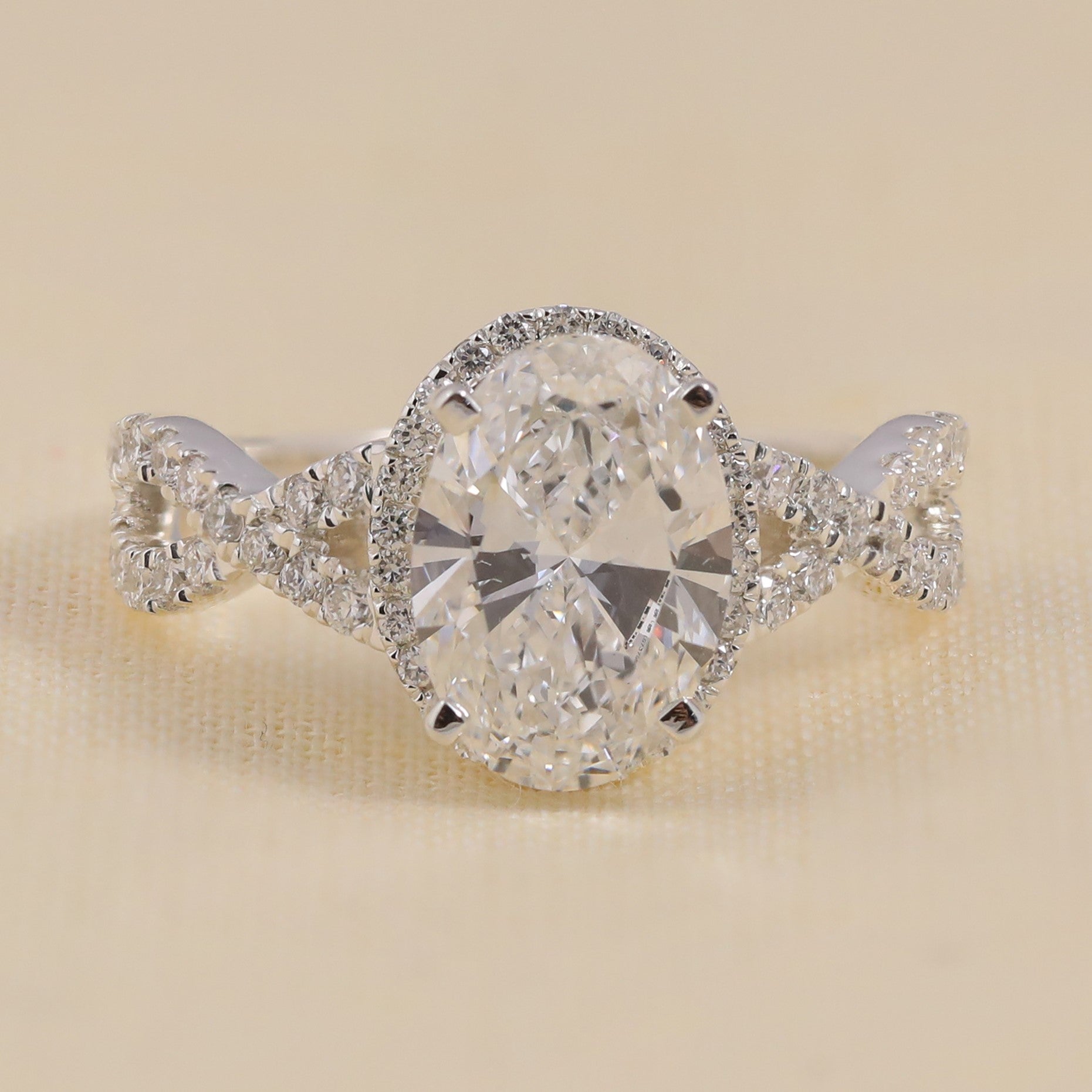 Oval diamond engagement ring with twisted pavé band in white gold