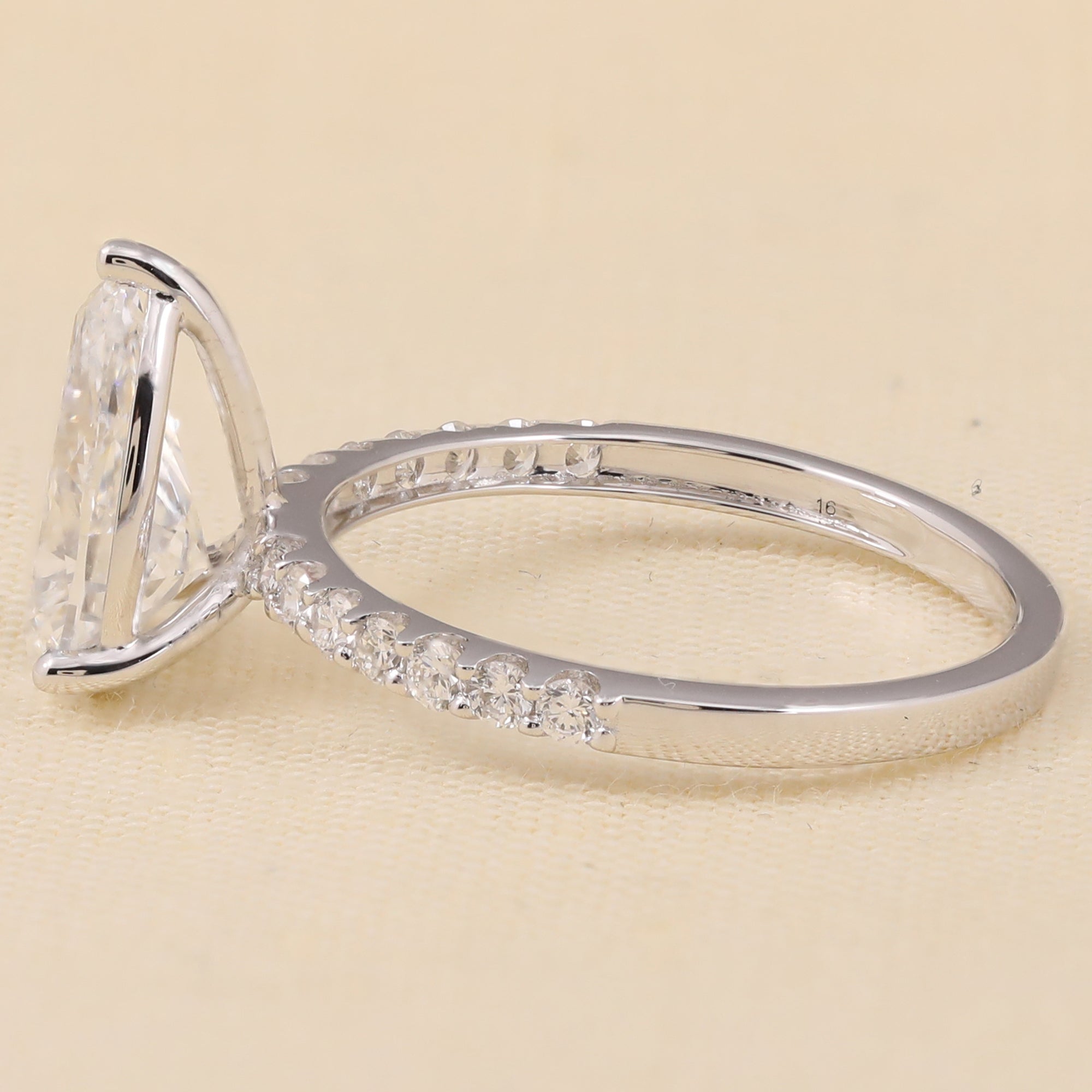 Solitaire pear lab diamond engagement ring accented with small lab diamonds on the band