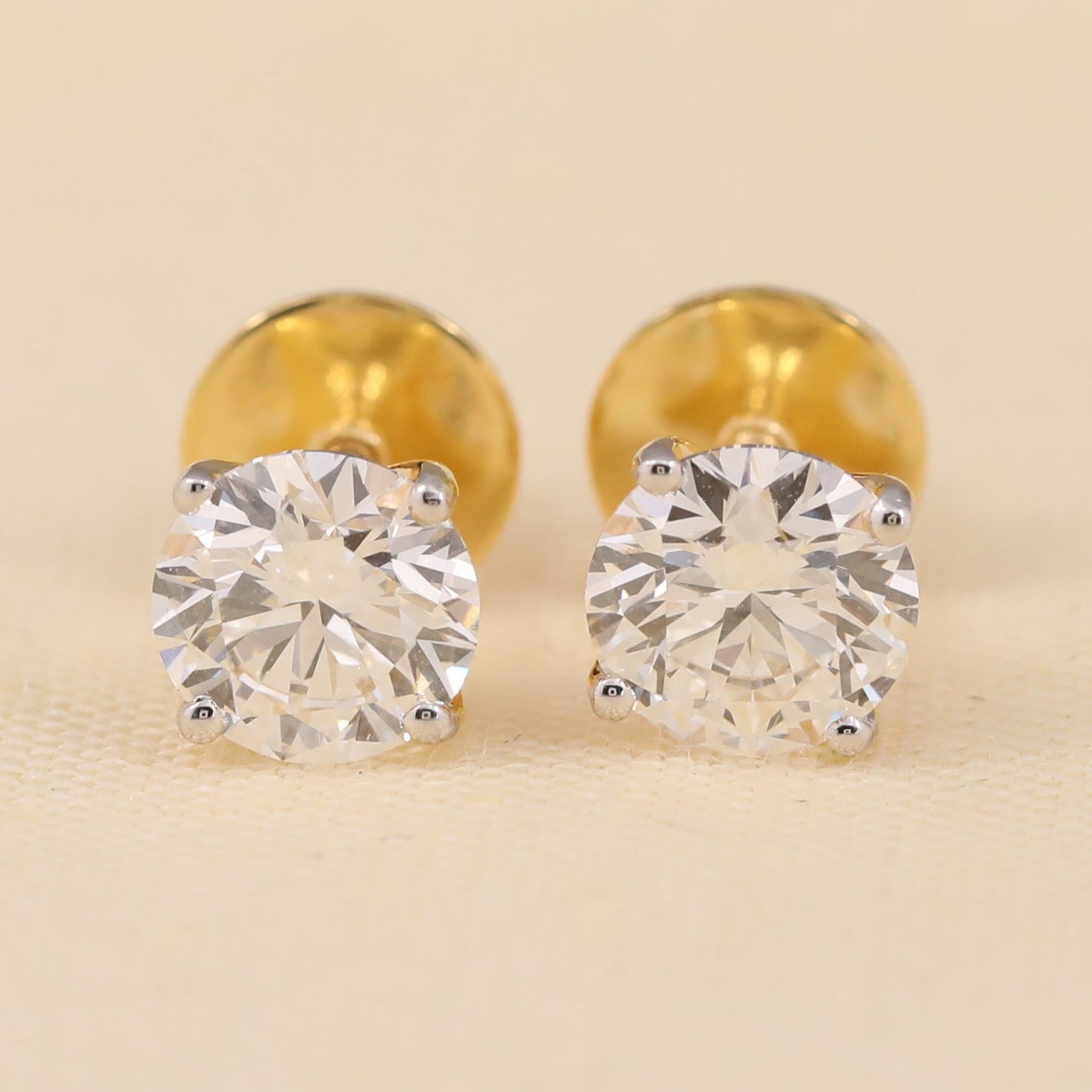 Round lab diamond stud earrings with secure screw-back setting, classic solitaire design.