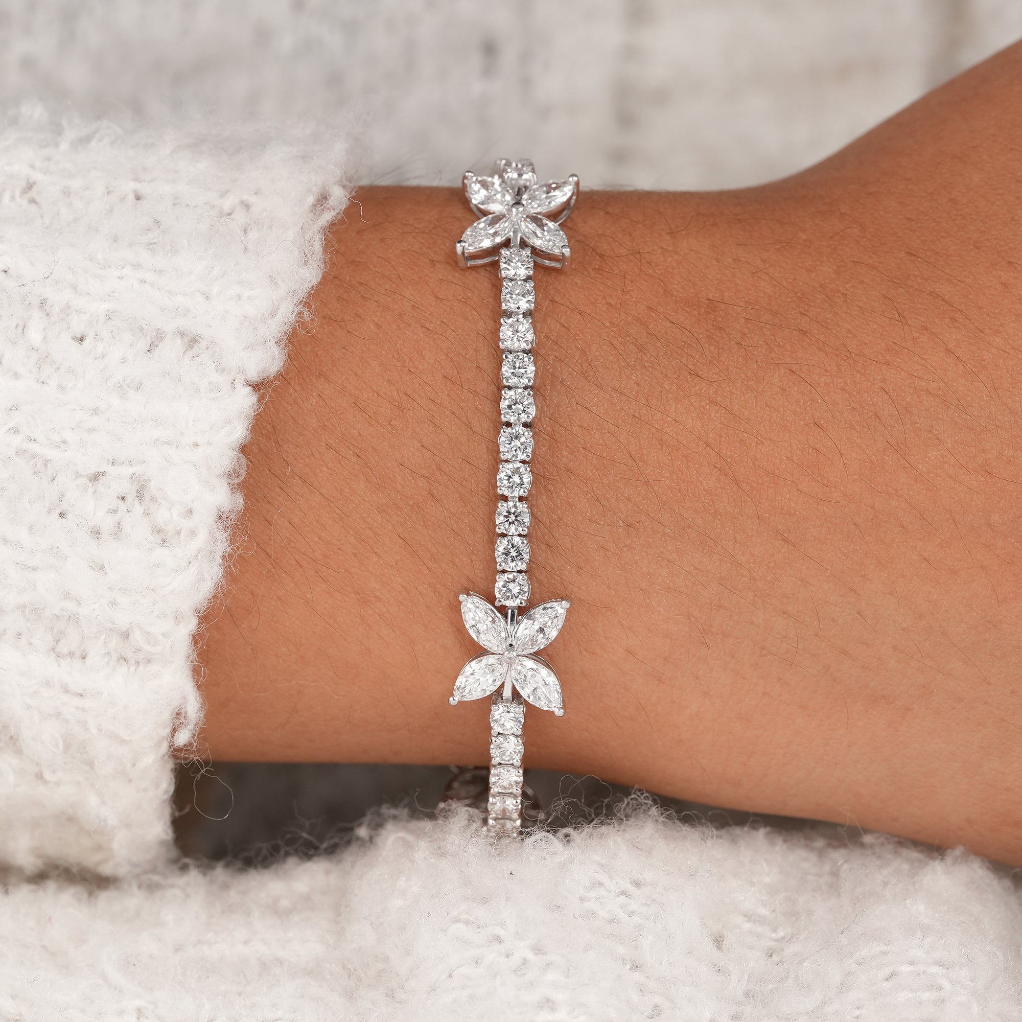 Luxury white gold diamond tennis bracelet featuring butterfly design.