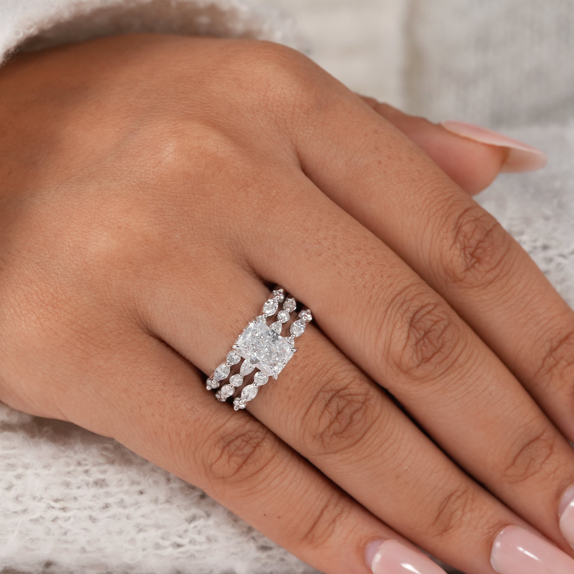 Radiant cut diamond engagement ring with matching wedding bands.