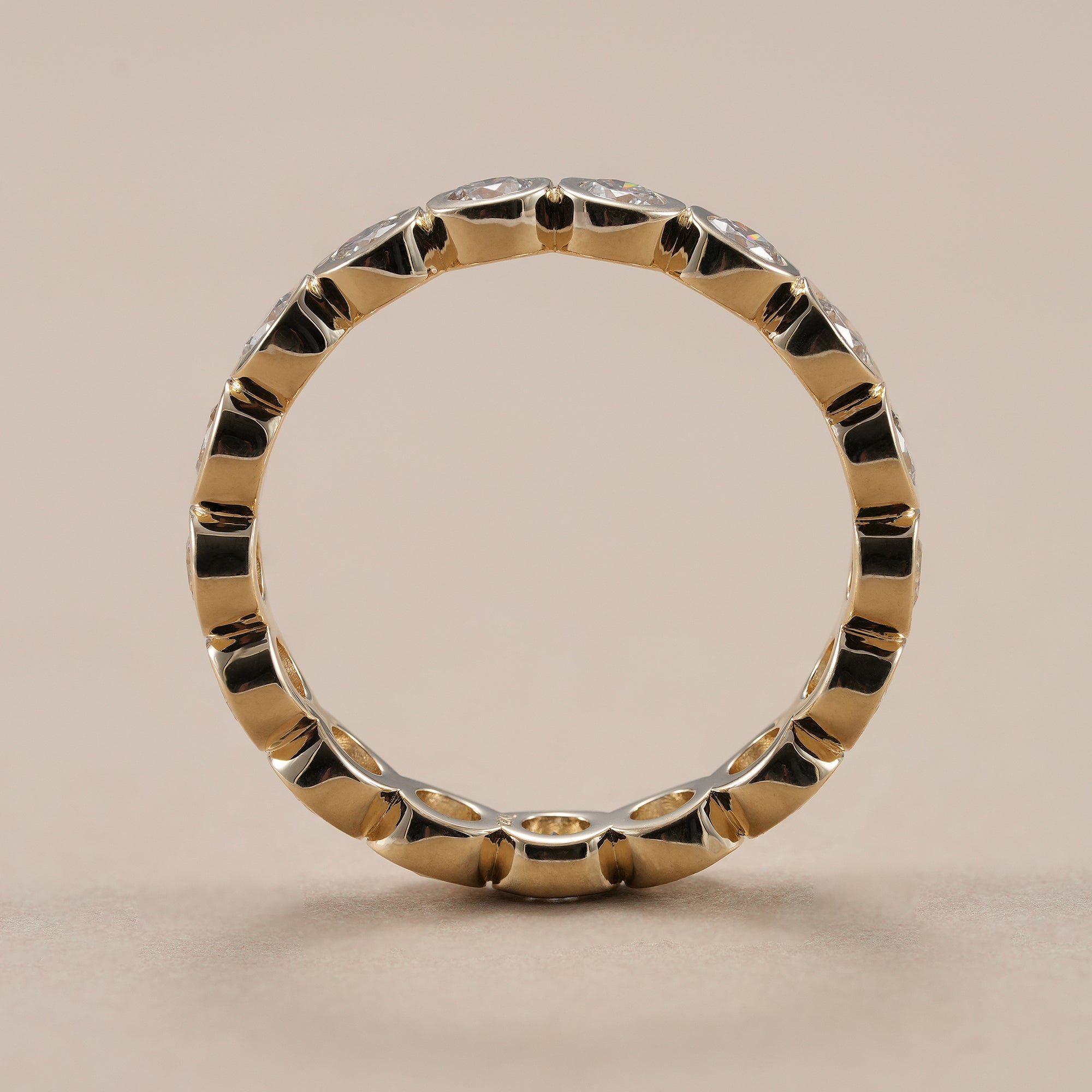 Lab grown diamond eternity wedding band with secure bezel setting.