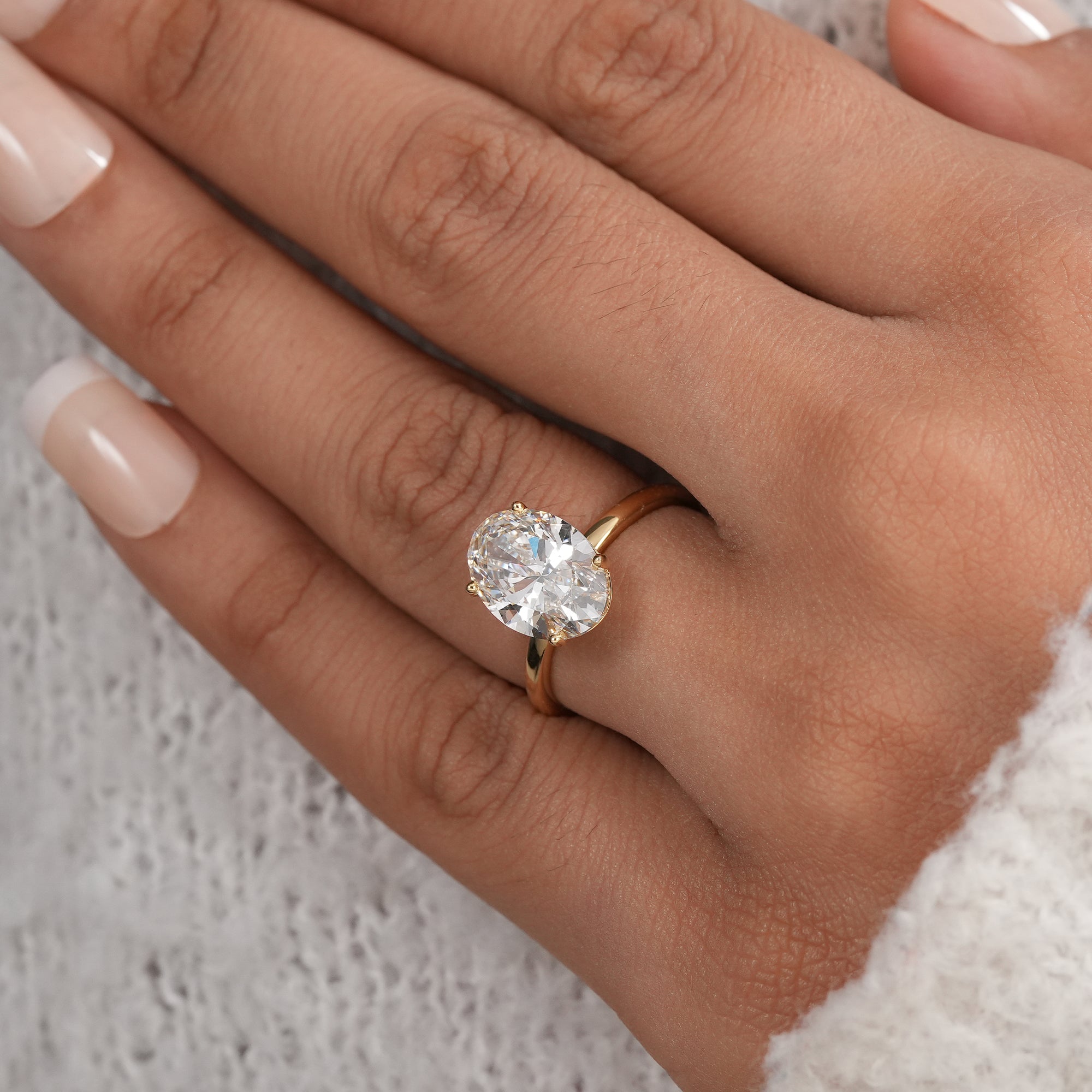 Oval cut lab grown diamond ring with four prong setting.