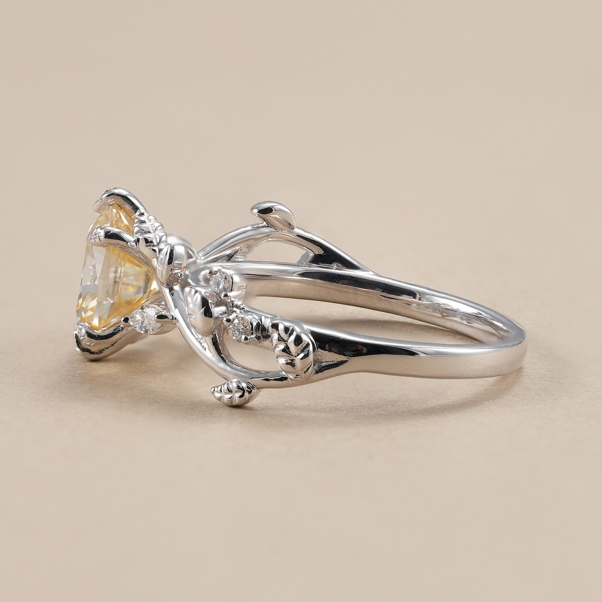 Nature inspired engagement ring with yellow cushion center diamond.