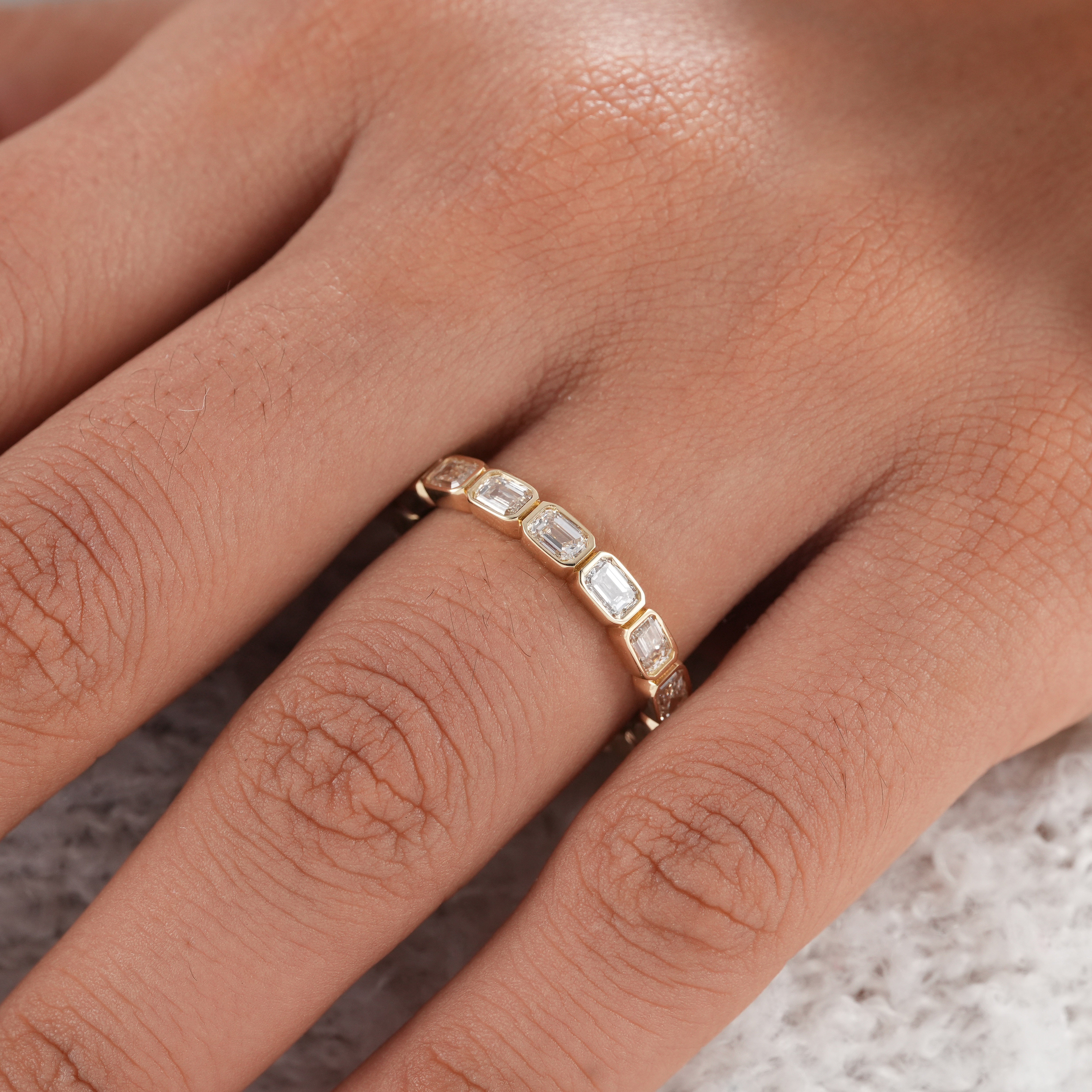 Yellow gold bezel set eternity ring with lab diamonds.