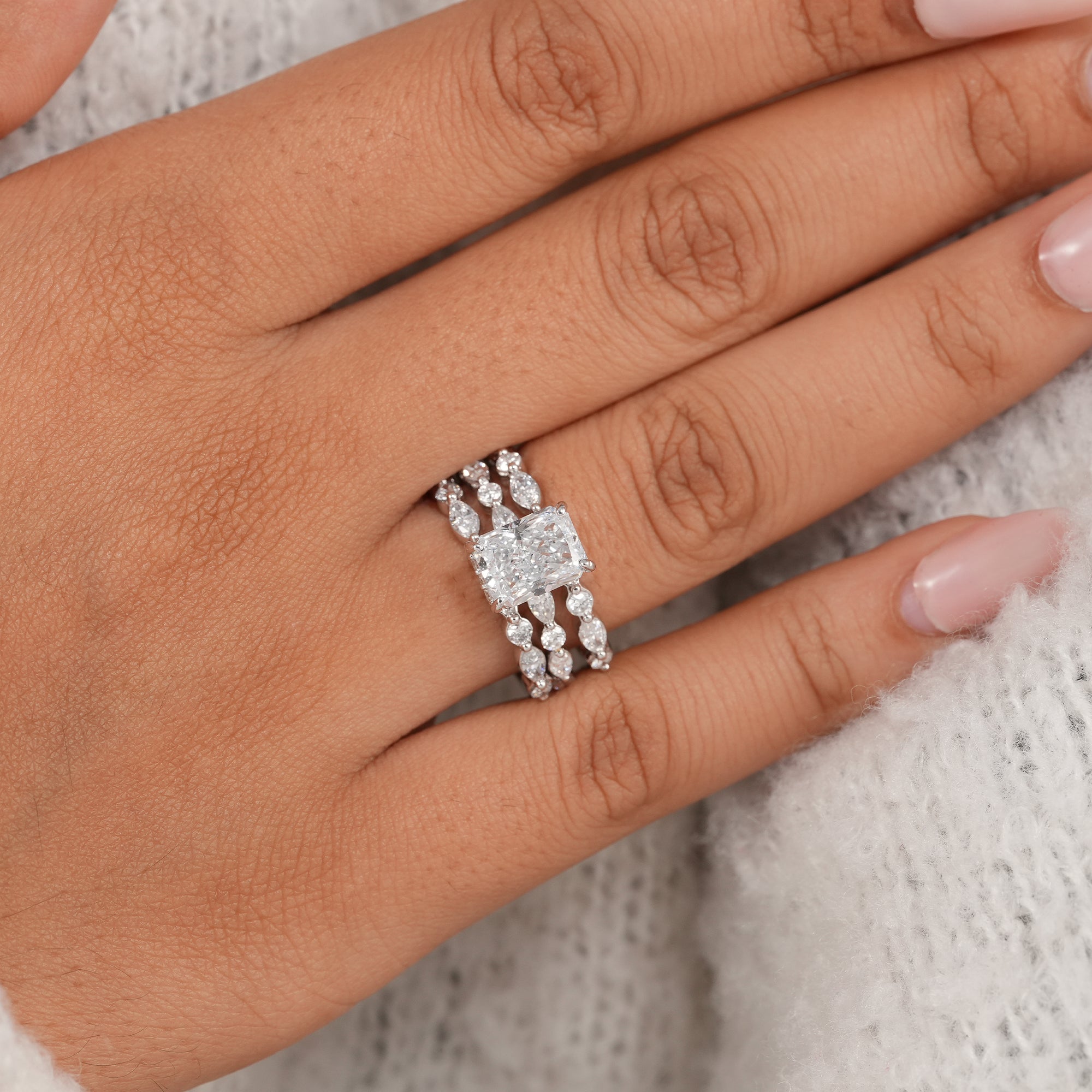 Elegant radiant cut engagement ring with stackable bands.