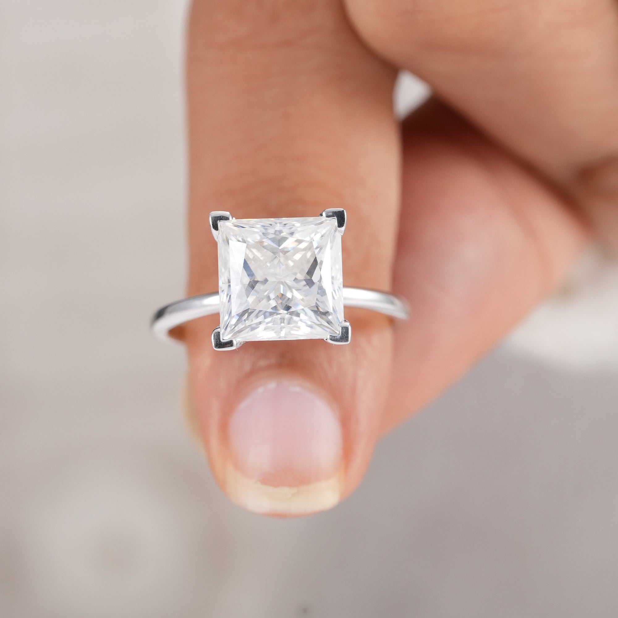 Minimalist solitaire princess diamond ring with polished band.