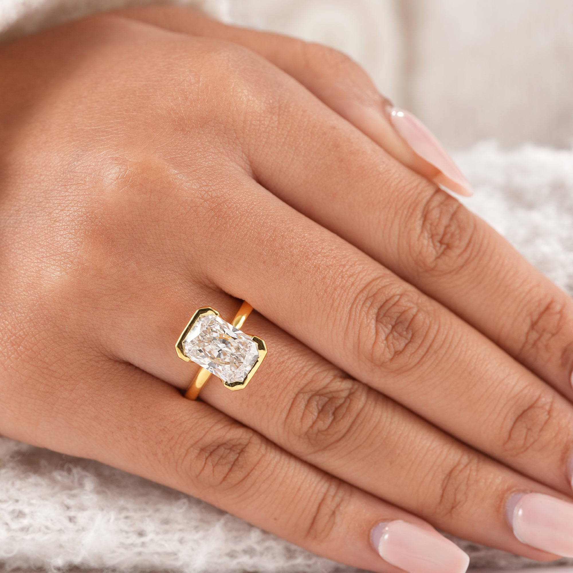 Handmade radiant solitaire diamond ring with polished gold band.