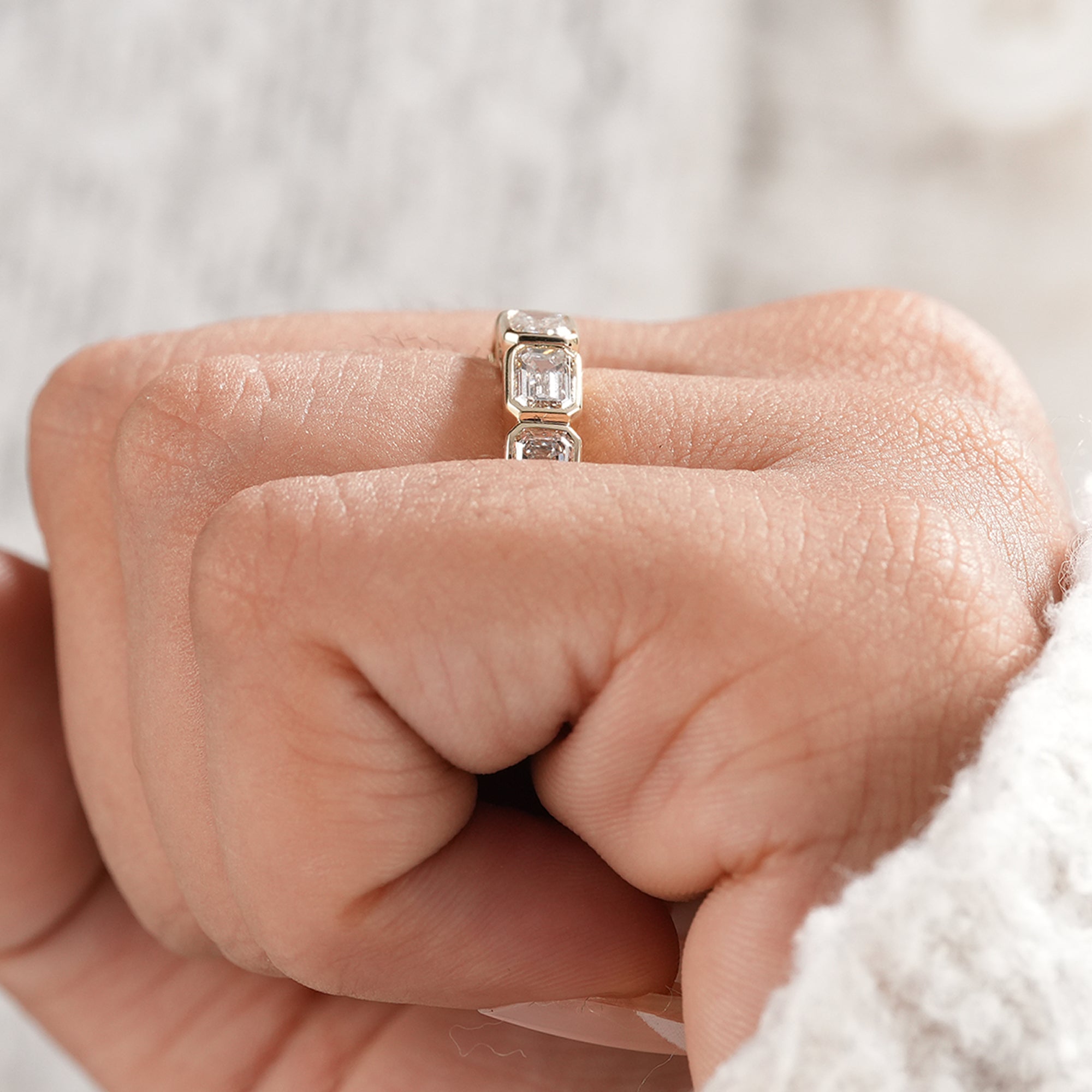 Minimalist emerald eternity ring with five diamonds.