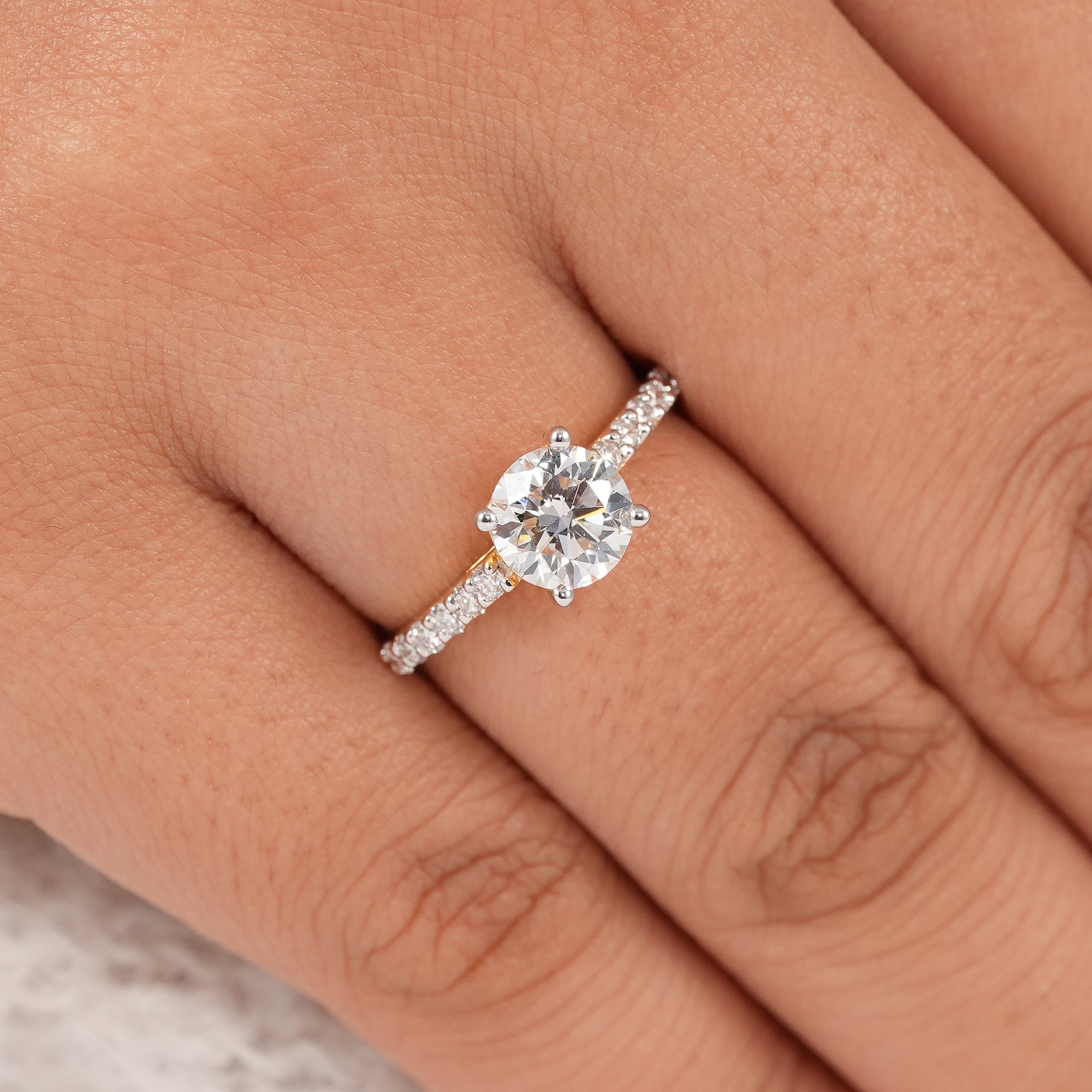 Round brilliant solitaire ring with pavé accent diamonds