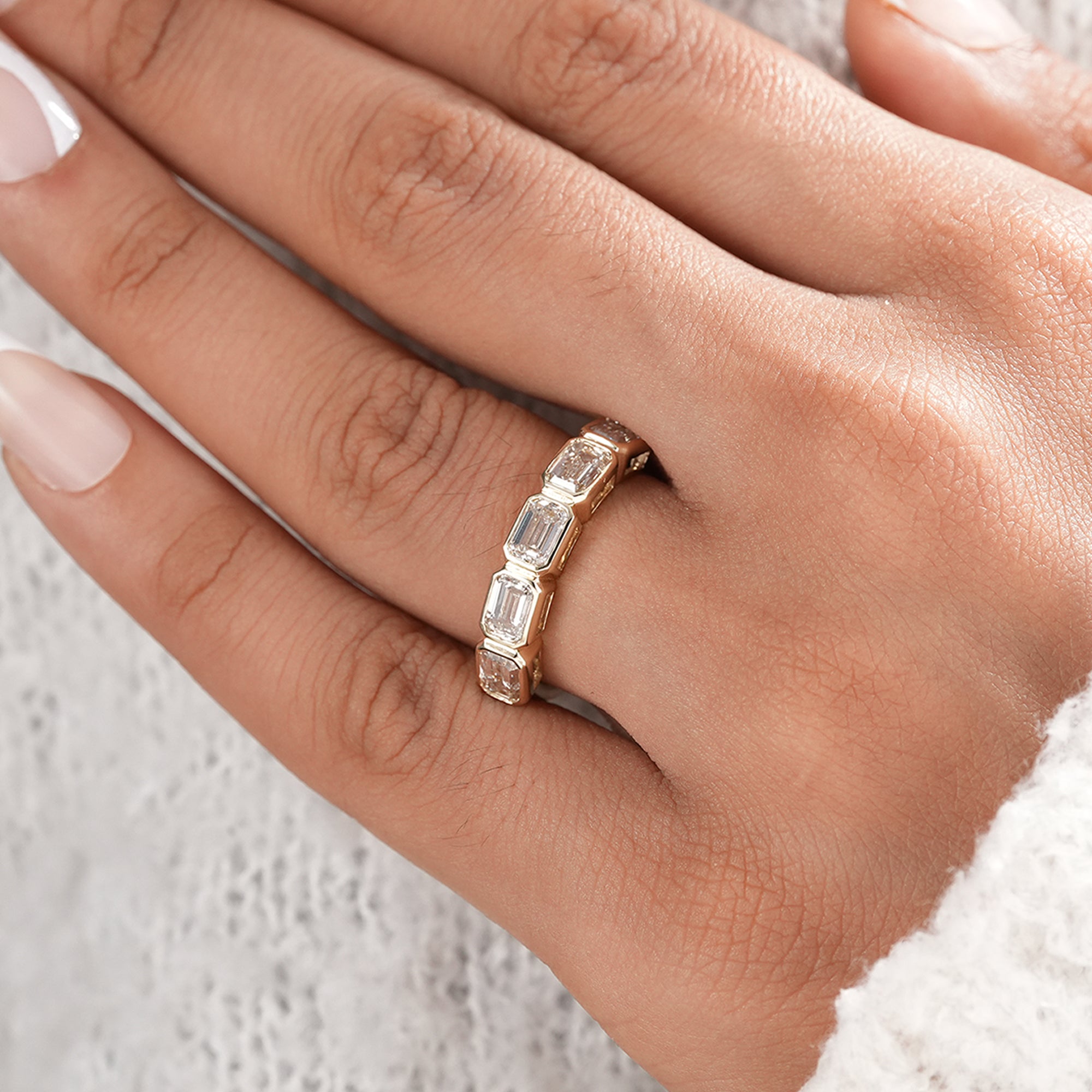 Handmade emerald diamond wedding band with bezel setting.