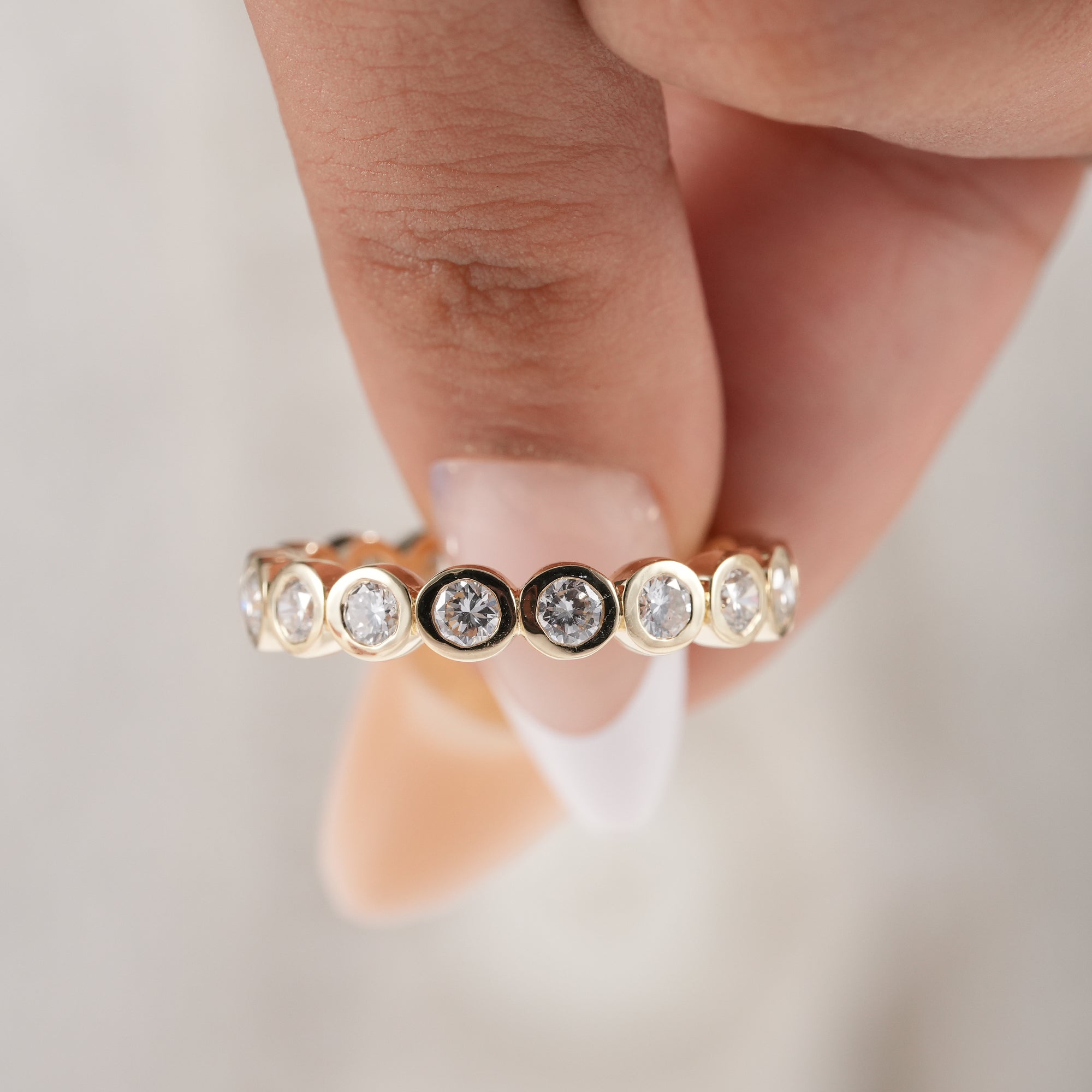Sustainable lab diamond eternity band with polished gold finish.