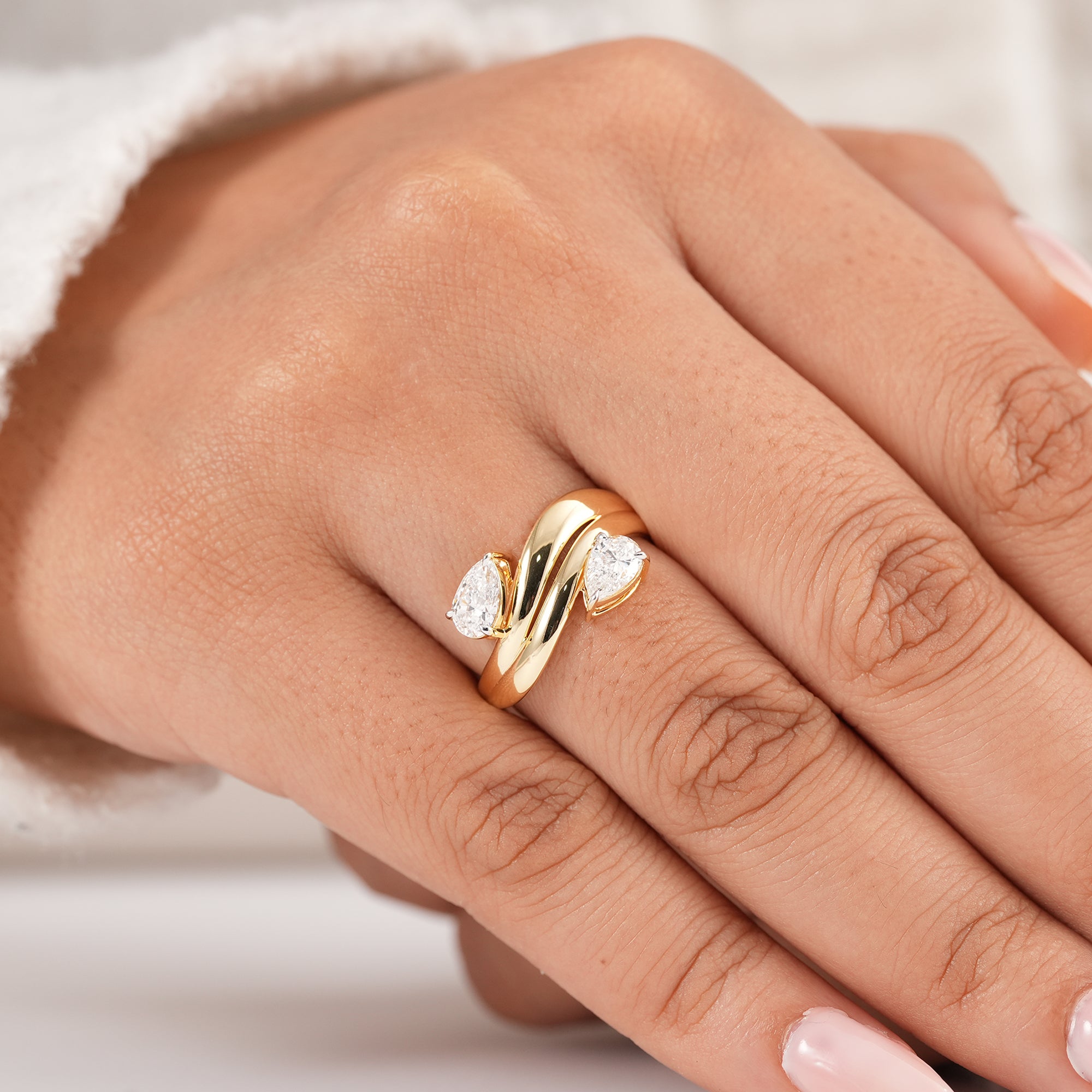Modern two stone pear diamond ring with sculptural wave band design