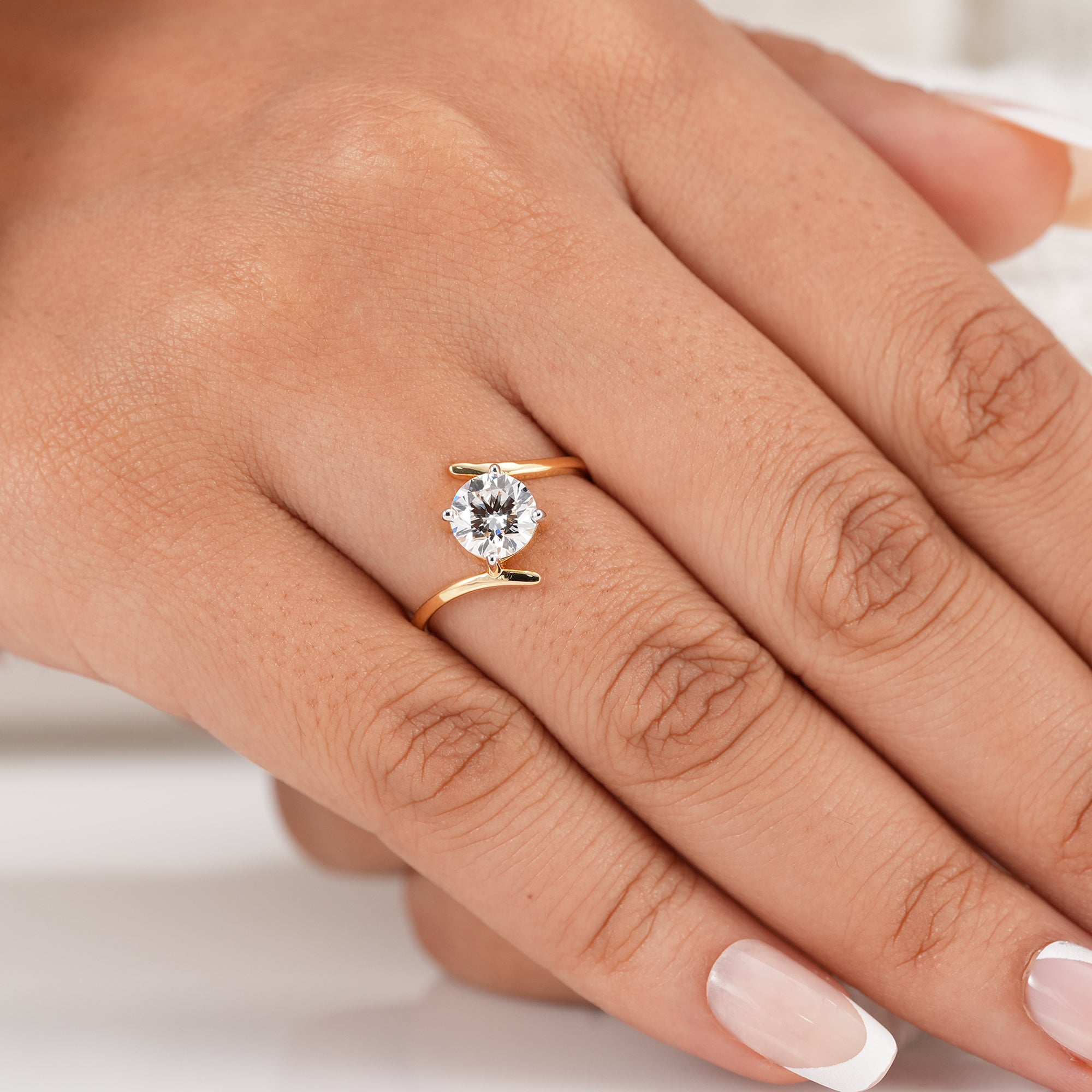 Four prong round diamond bypass solitaire ring