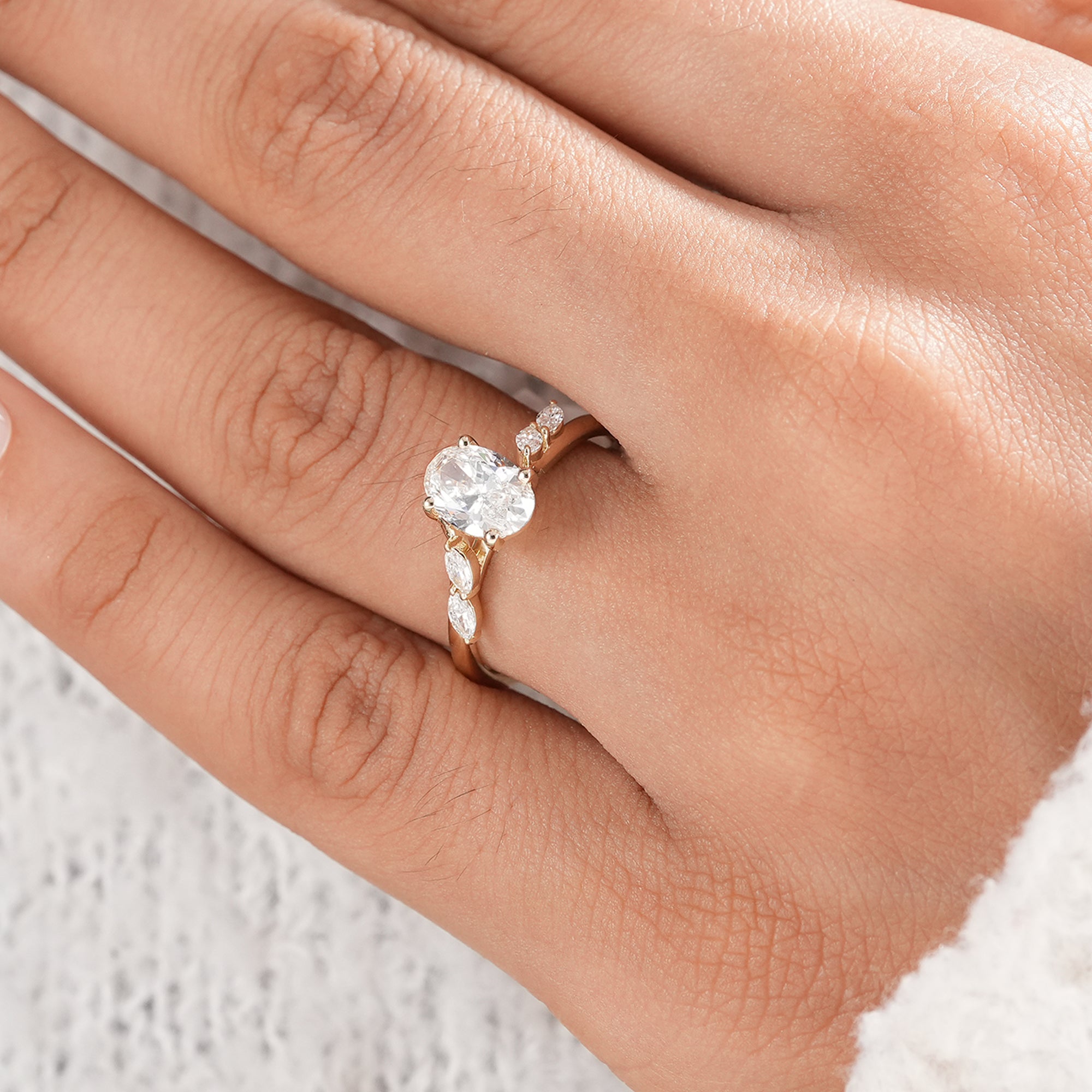 Oval solitaire engagement ring with leaf inspired diamond accents.