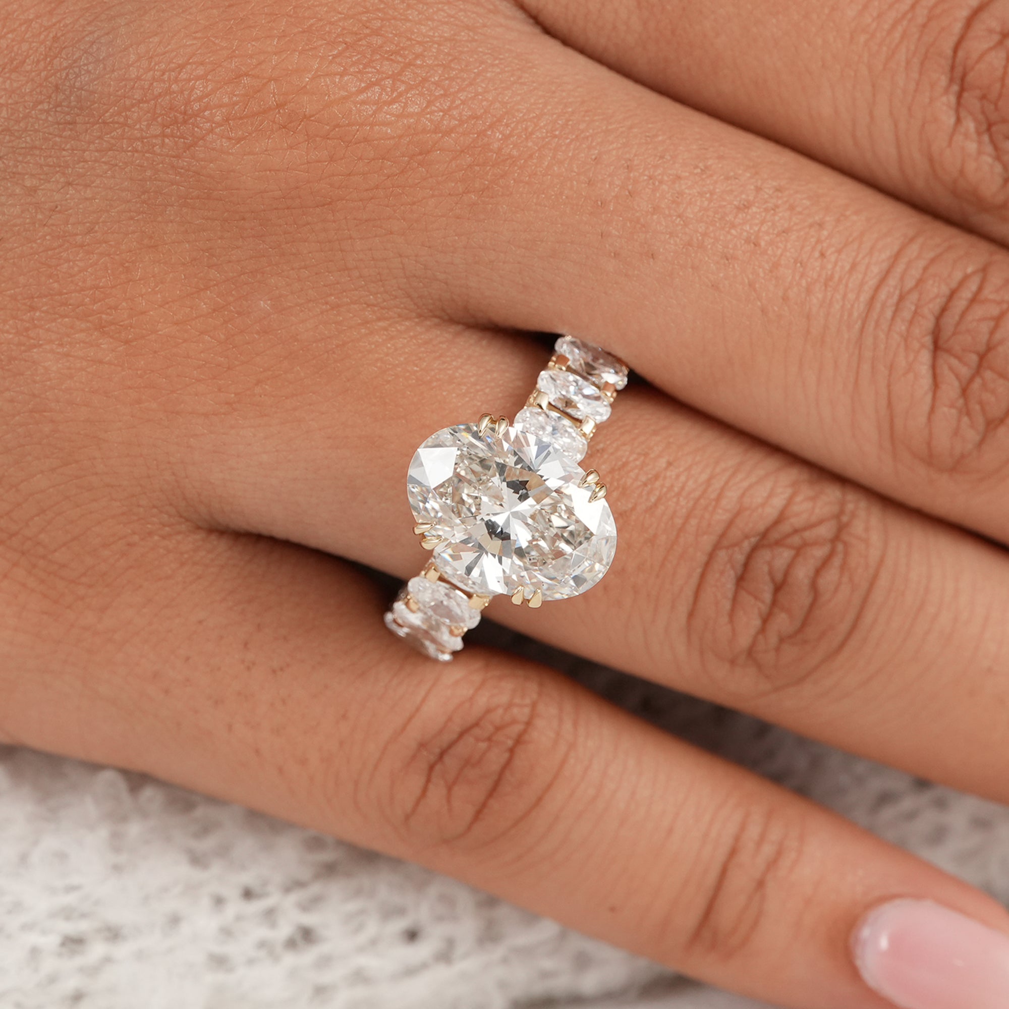 Oval lab diamond bridal ring with oval diamond accents and shimmering round pavé detailing.