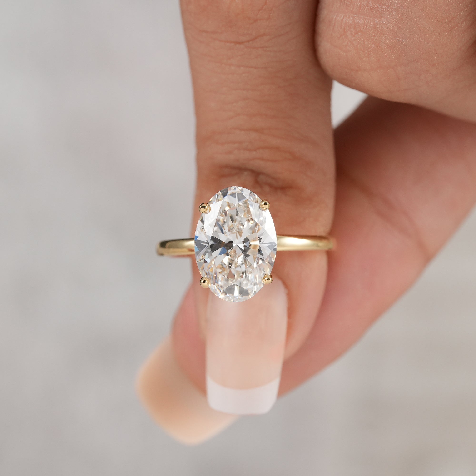 3.5 CT oval diamond engagement ring with slim gold band.