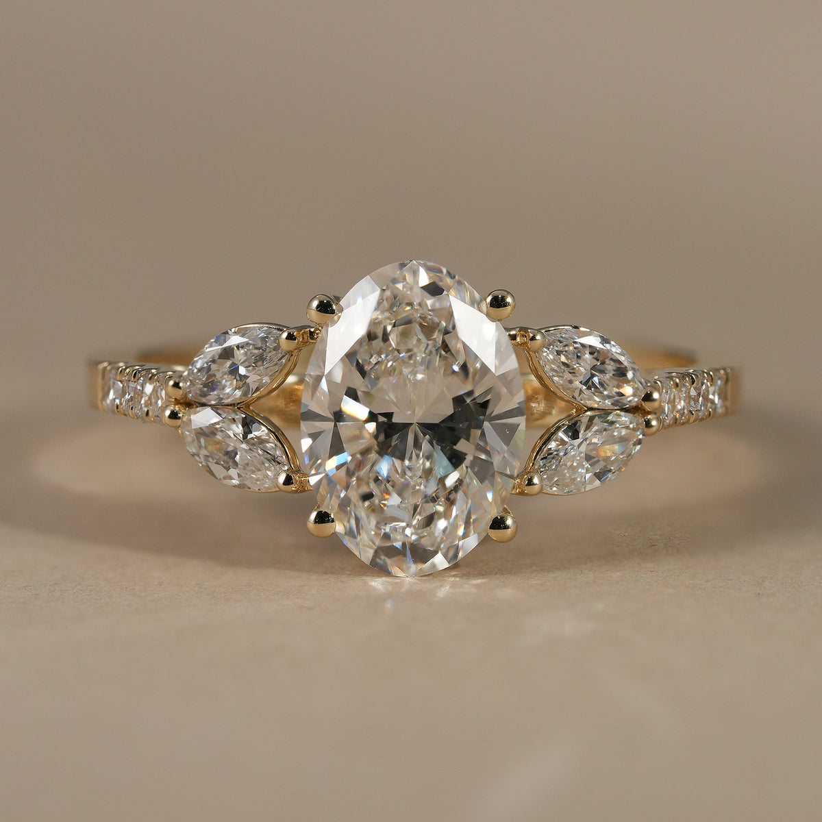 Oval cut lab grown diamond engagement ring with floral marquise diamond cluster accents in solid gold.