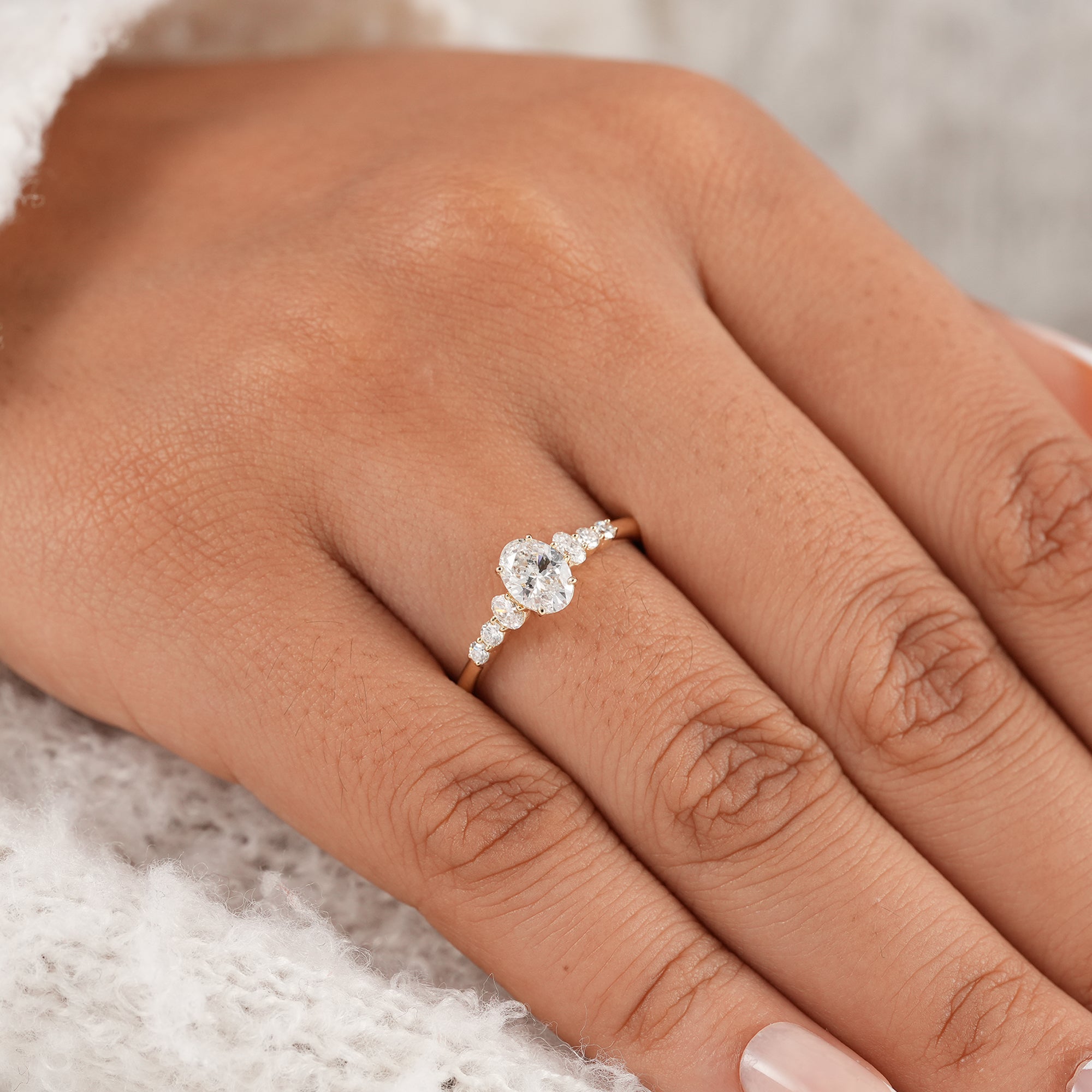 Oval solitaire ring featuring round and oval side stones
