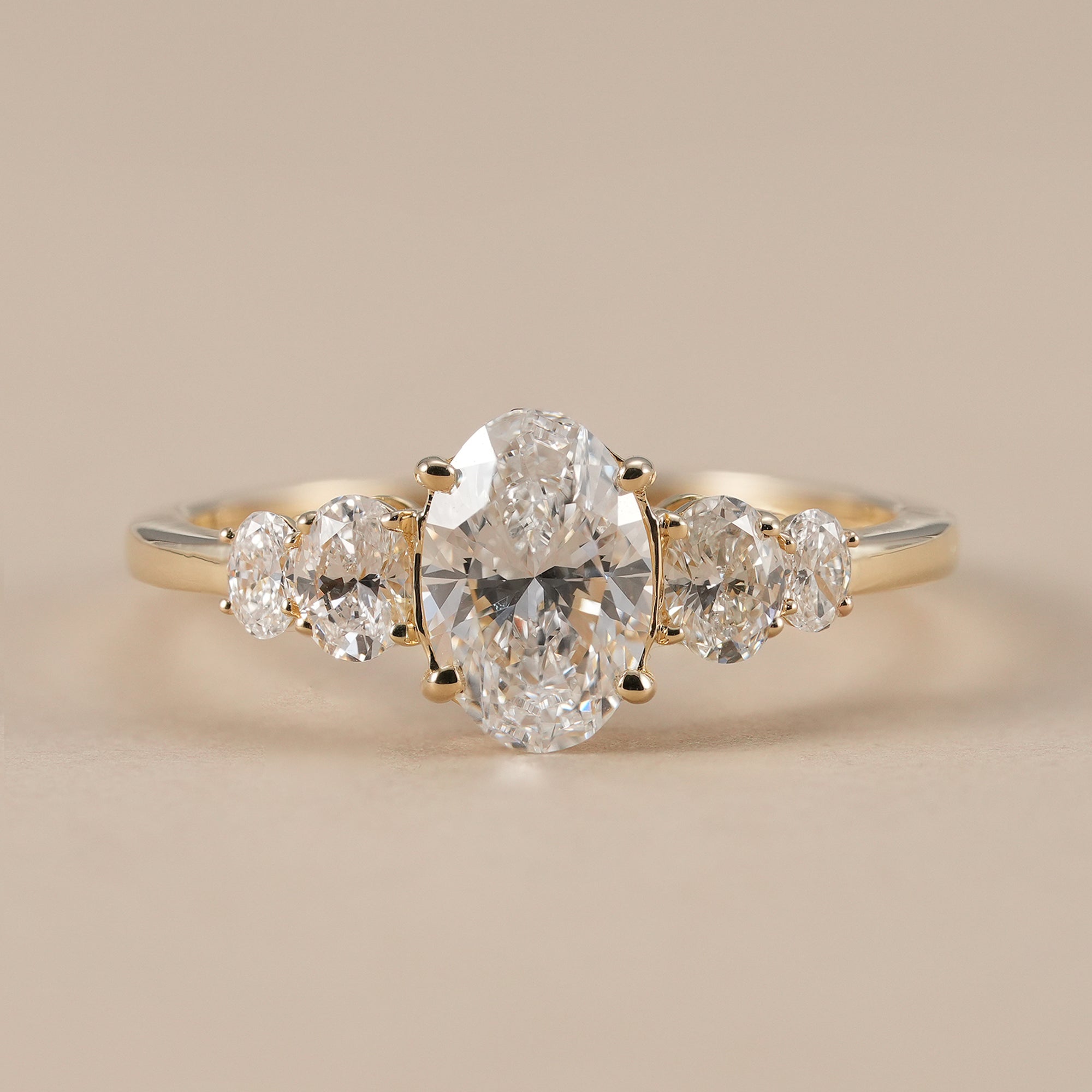 Oval lab grown diamond five stone engagement ring in yellow gold