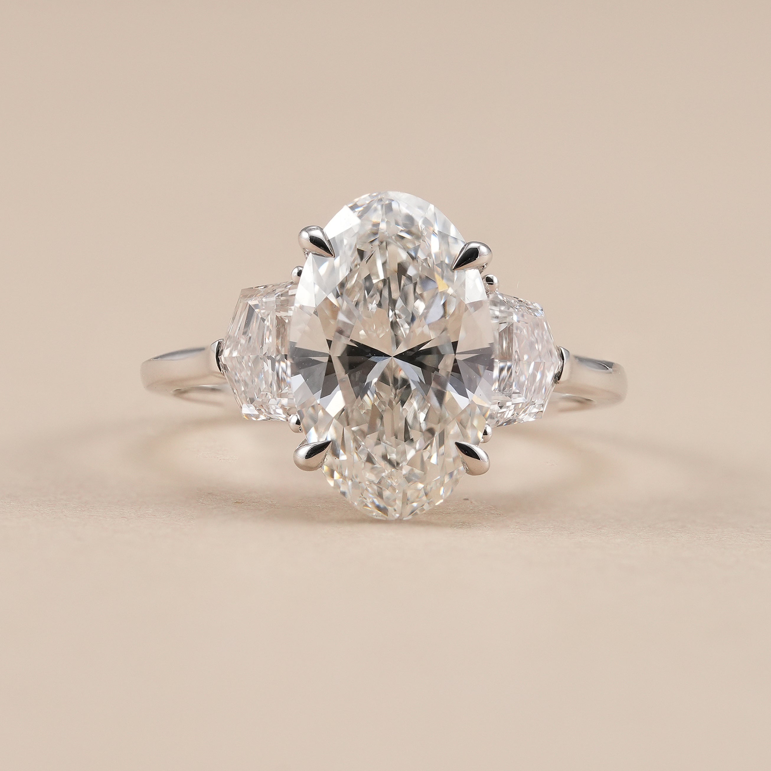 Oval lab grown diamond three stone engagement ring with Cadillac side diamonds