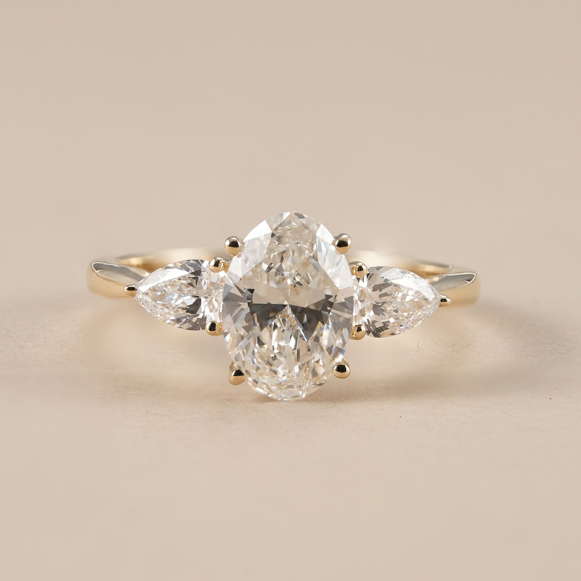 Oval lab grown diamond three stone engagement ring with pear side diamonds