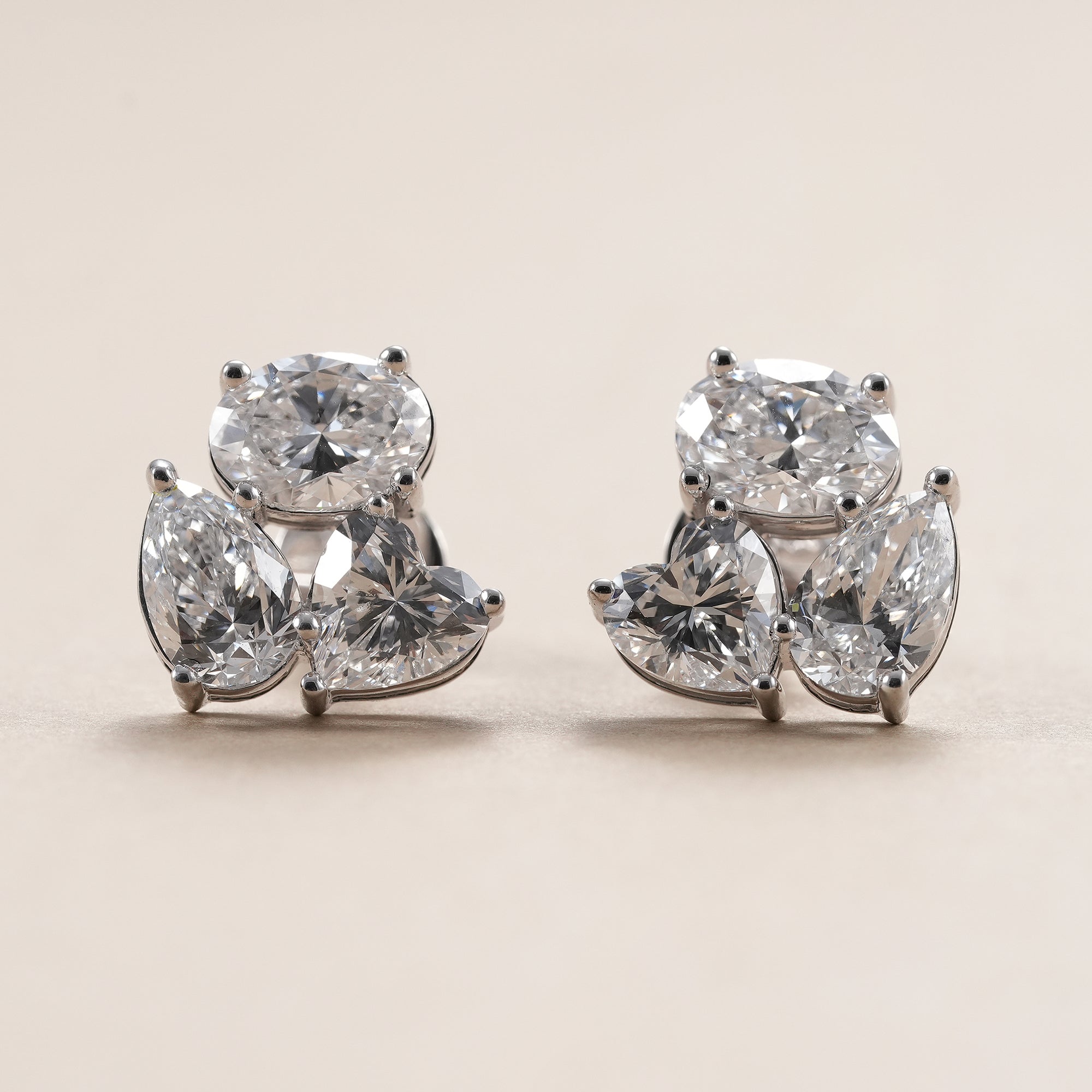 Oval pear heart lab grown diamond cluster stud earrings in white gold.