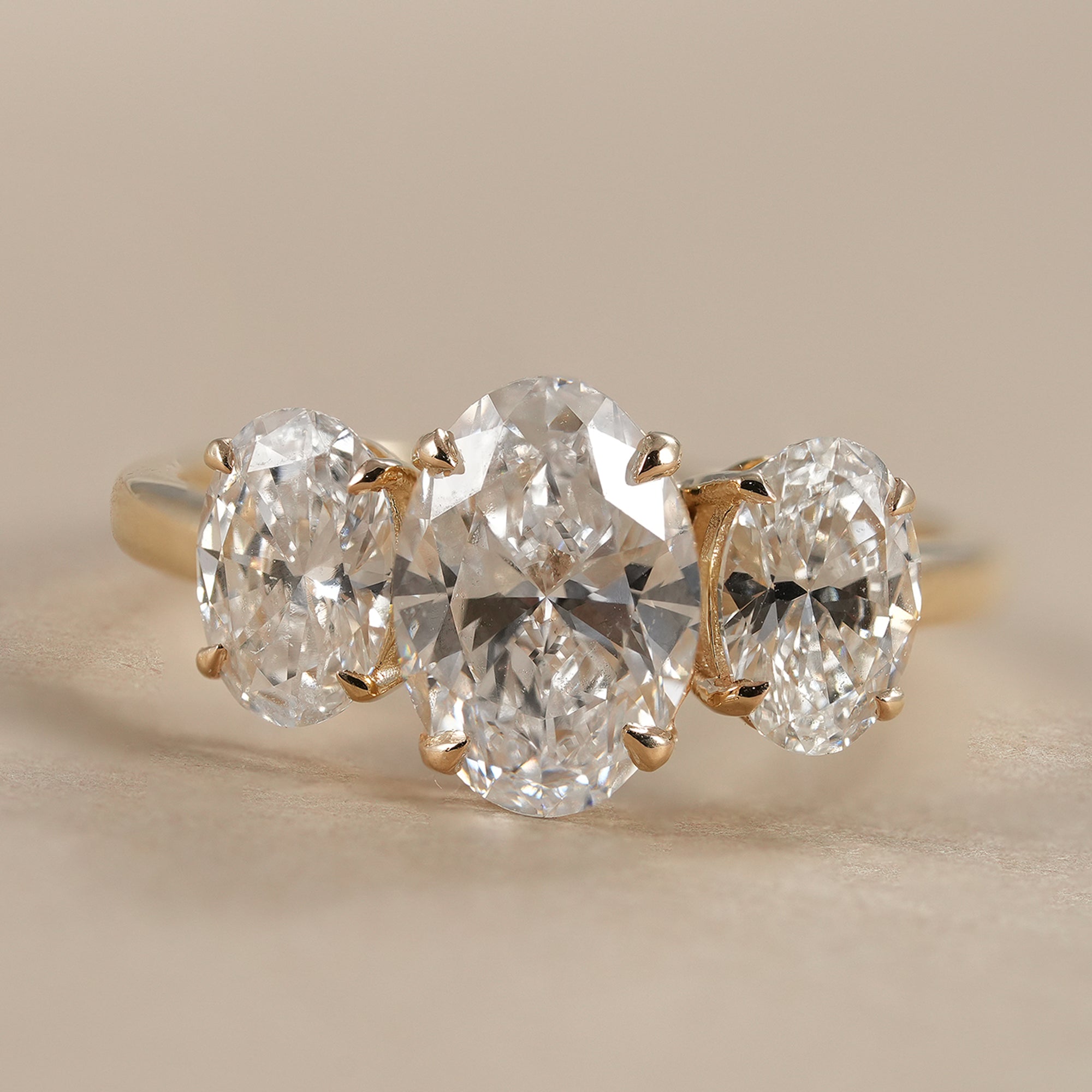 Oval three stone lab grown diamond engagement ring in yellow gold
