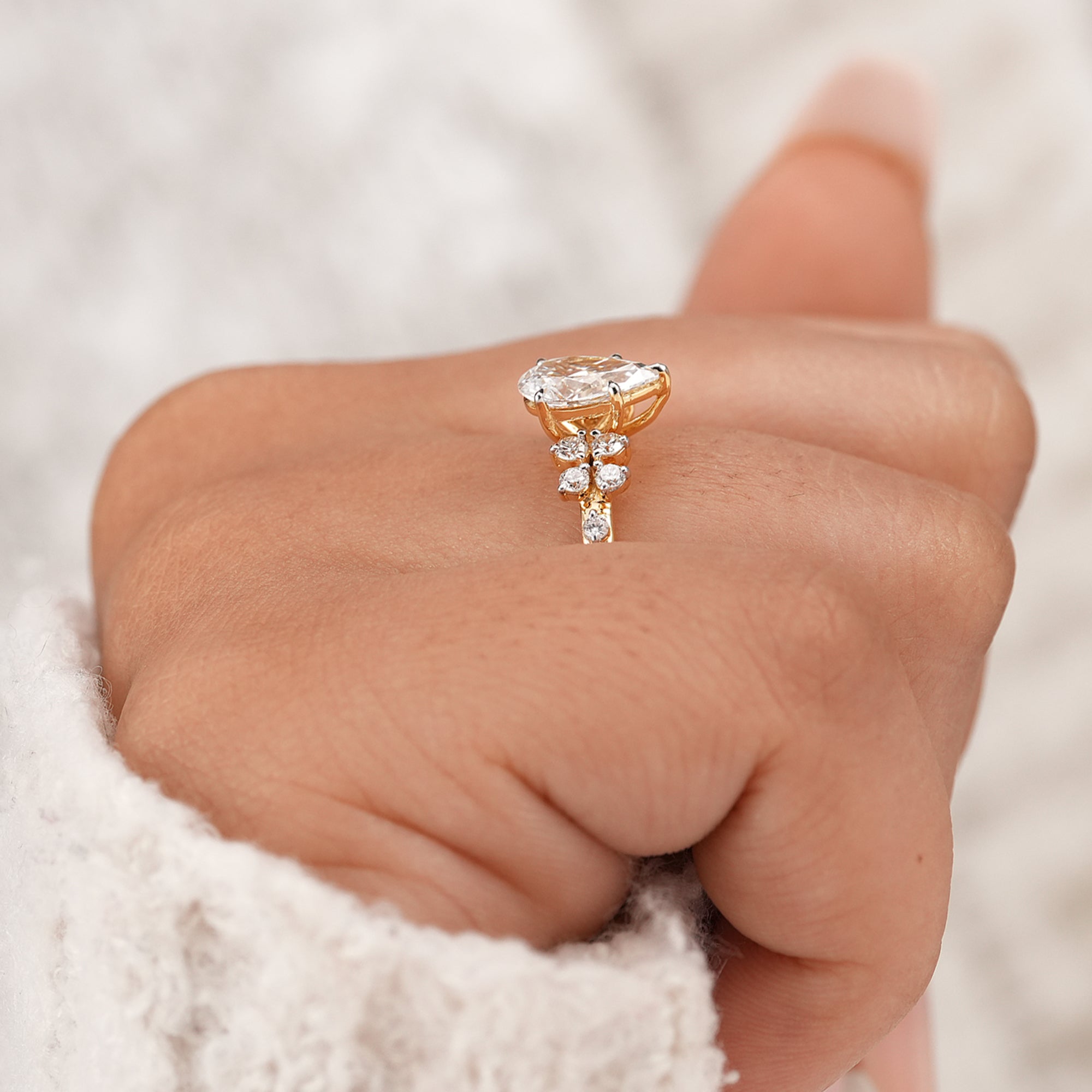Pear cut engagement ring with delicate diamond cluster
