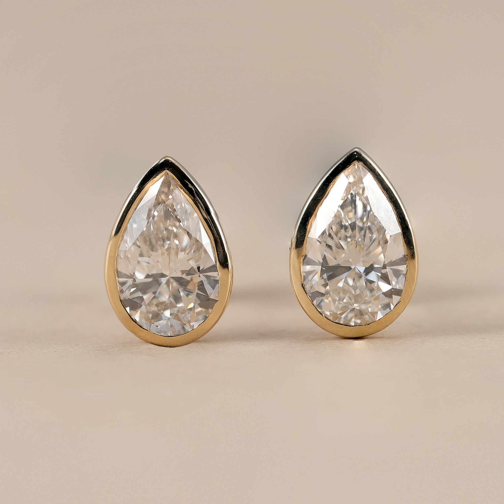 Pear bezel lab grown diamond stud earrings in yellow gold