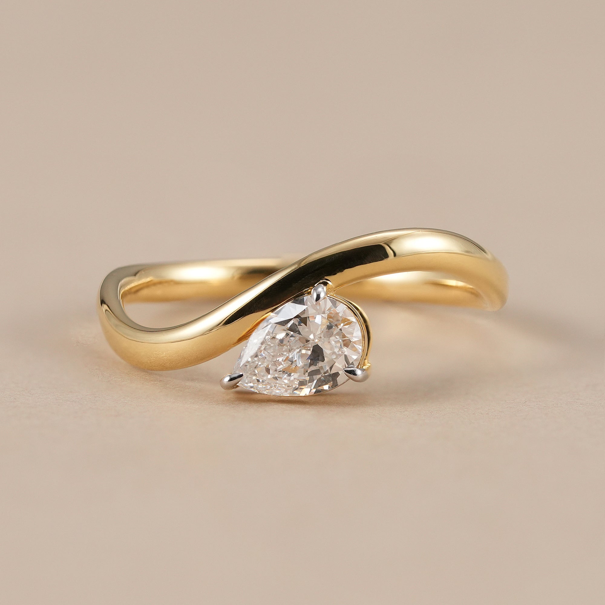 Pear cut lab grown diamond wave ring in solid yellow gold
