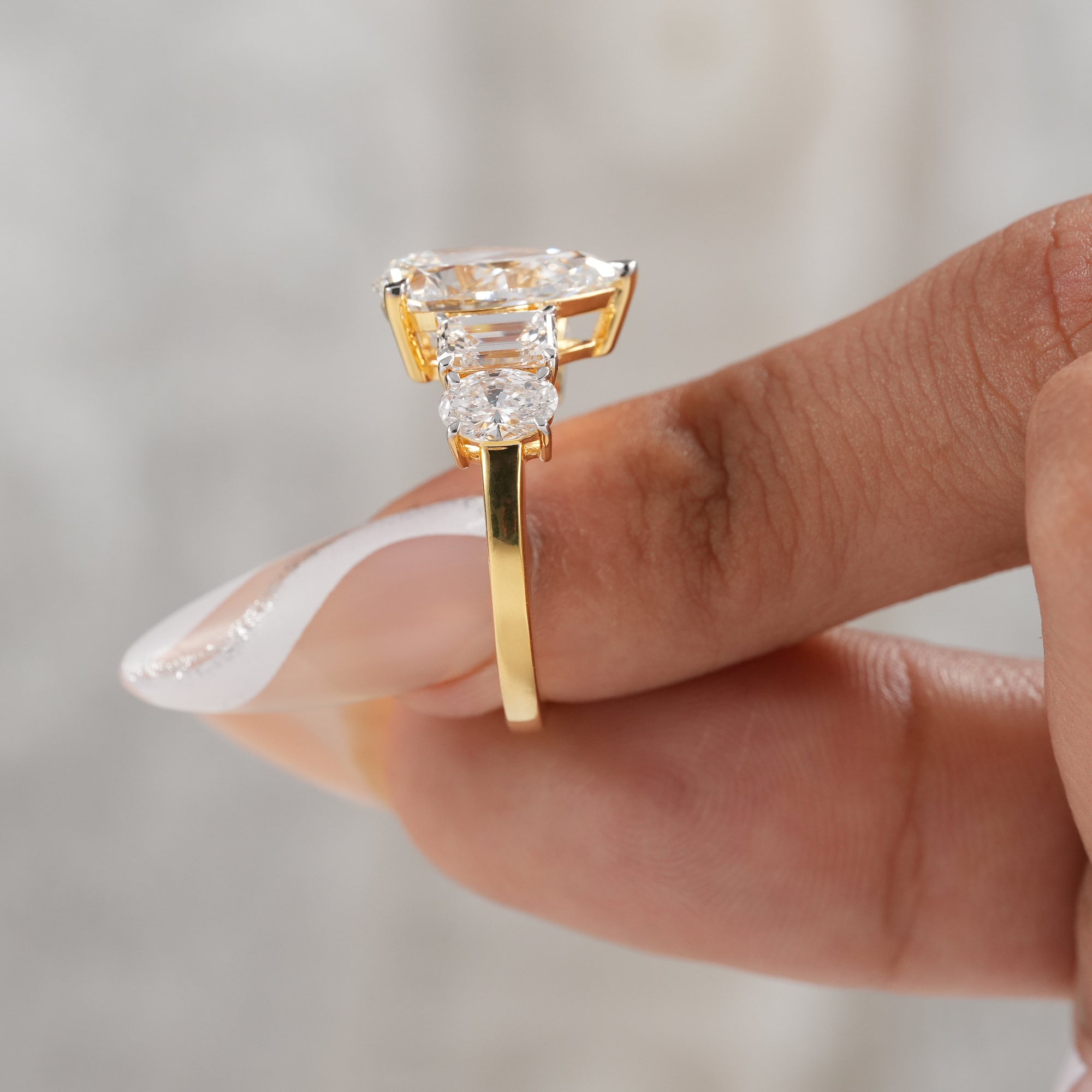 Pear diamond proposal ring with emerald cut side stones.