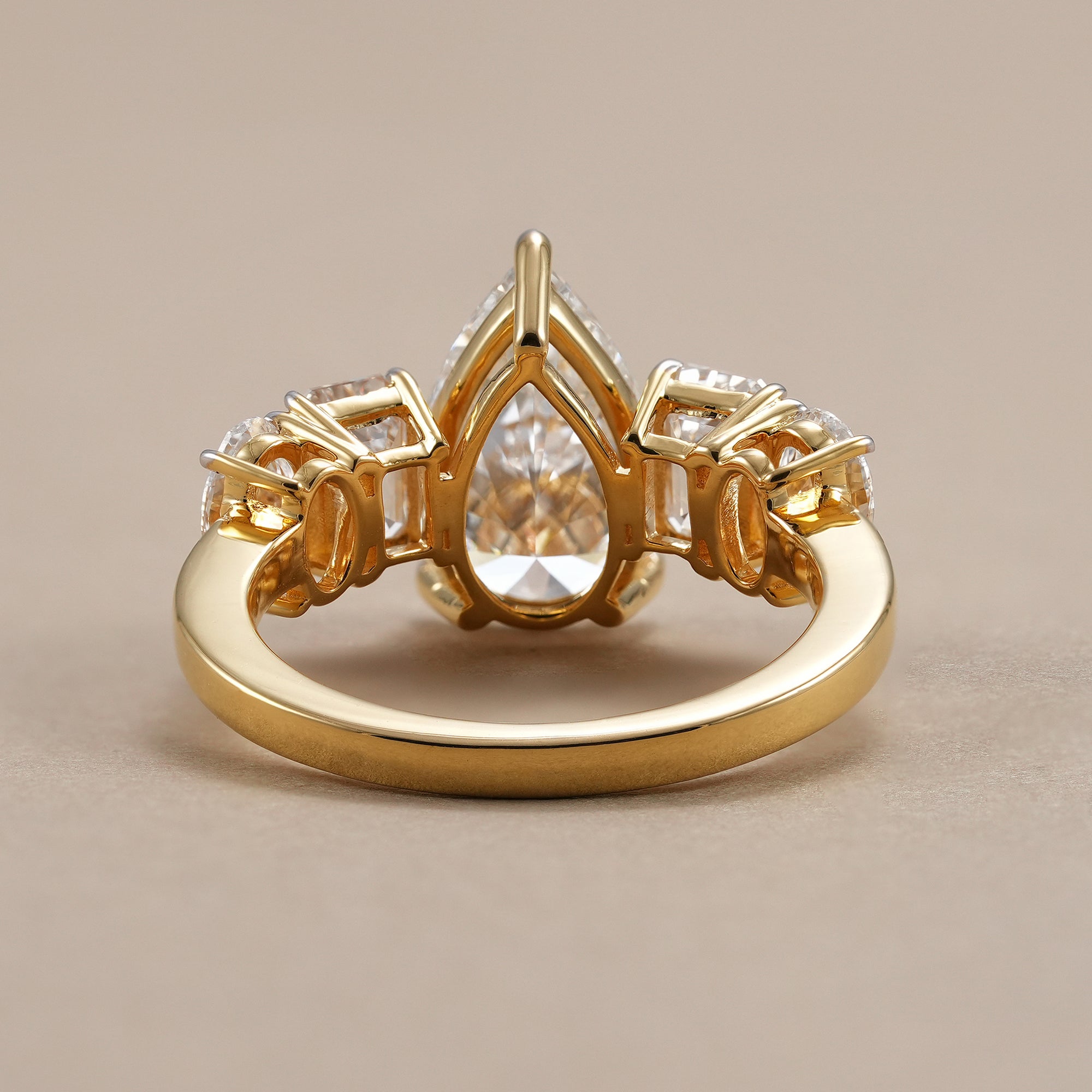Elegant pear diamond ring with emerald and oval diamonds.
