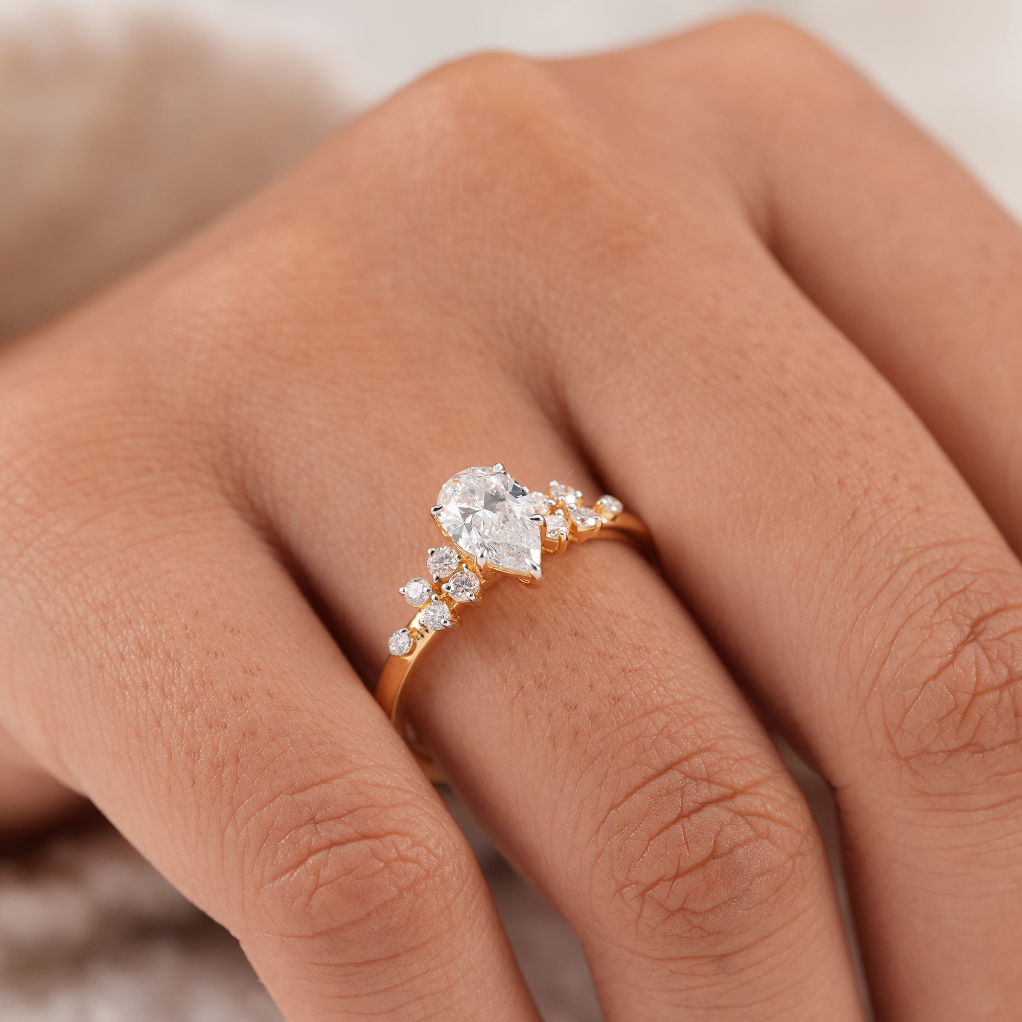 Pear diamond cluster engagement ring in yellow gold setting