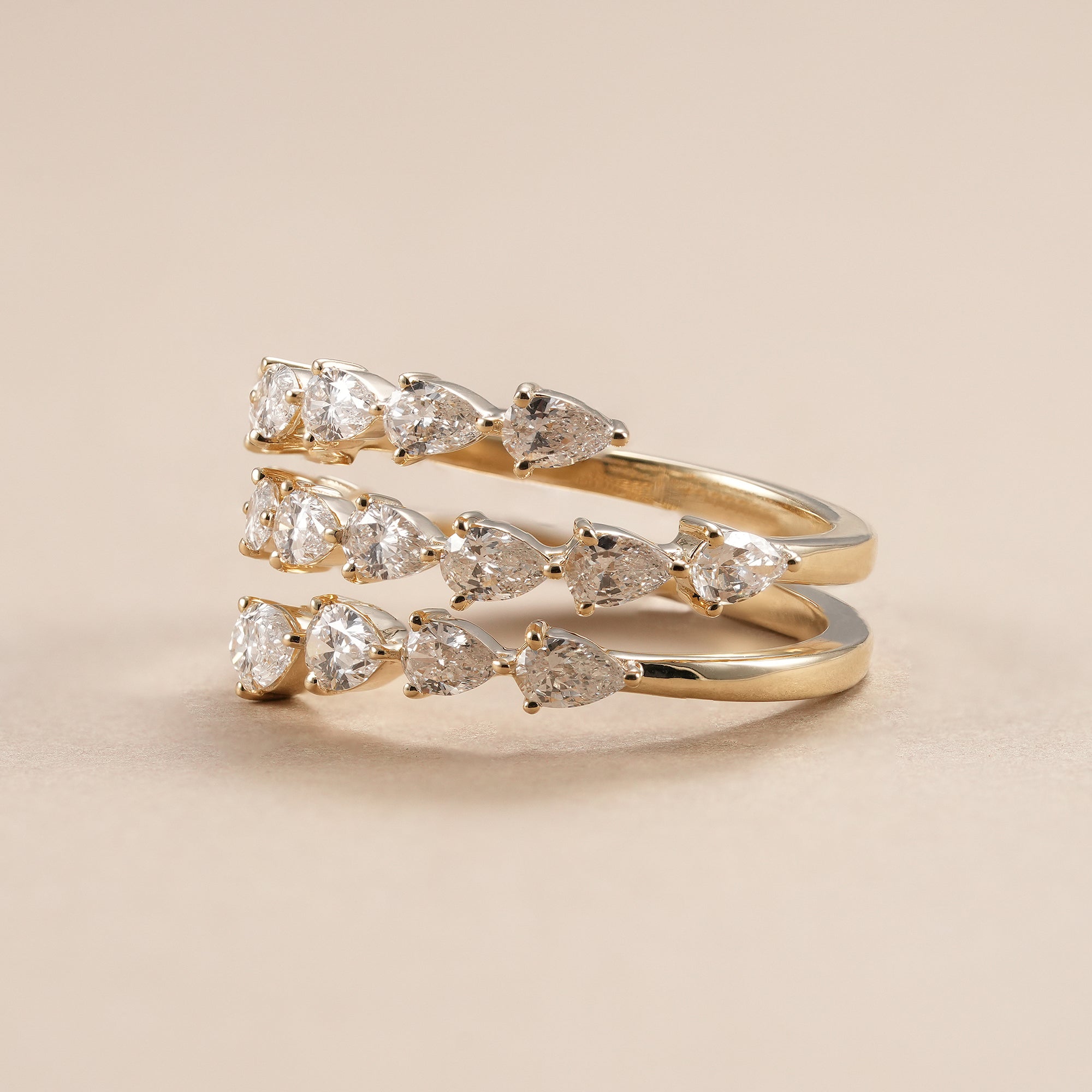 Luxury pear diamond eternity ring with triple row design.
