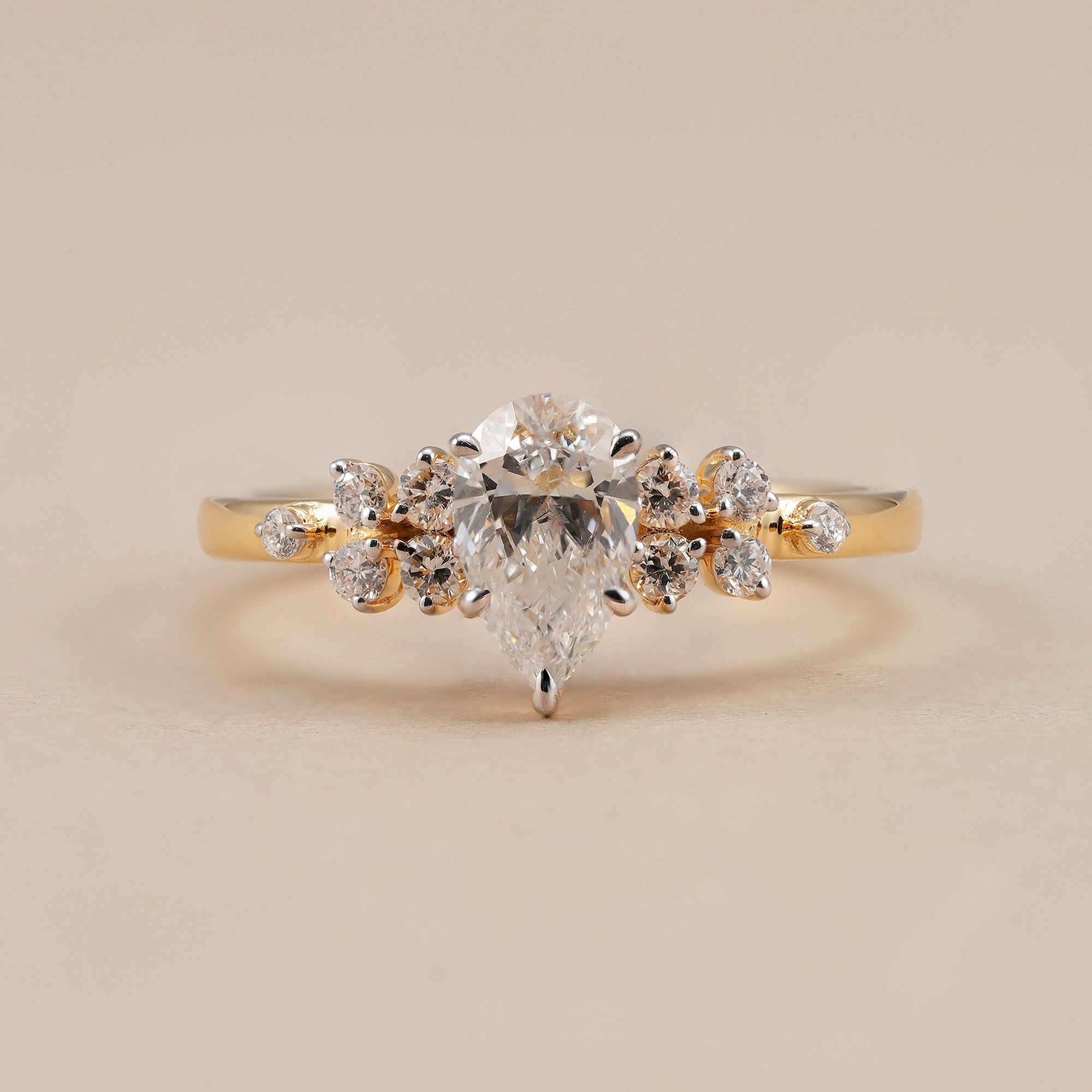 Pear lab grown diamond engagement ring with round accent stone cluster