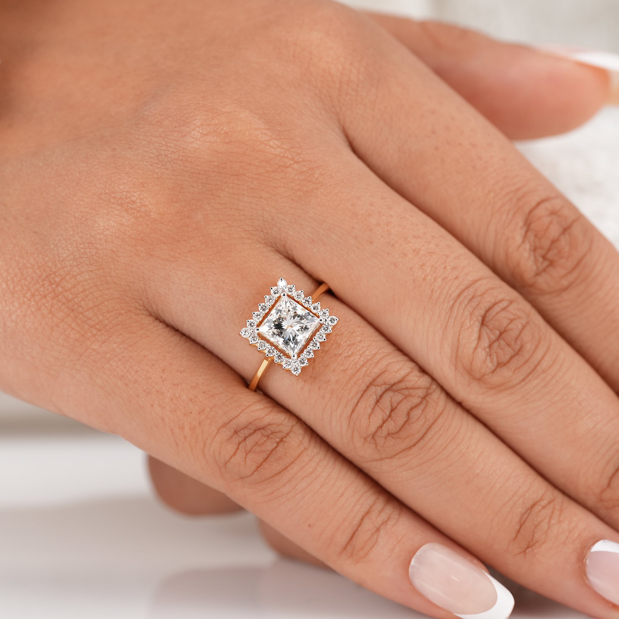 Princess cut halo engagement ring with polished gold band