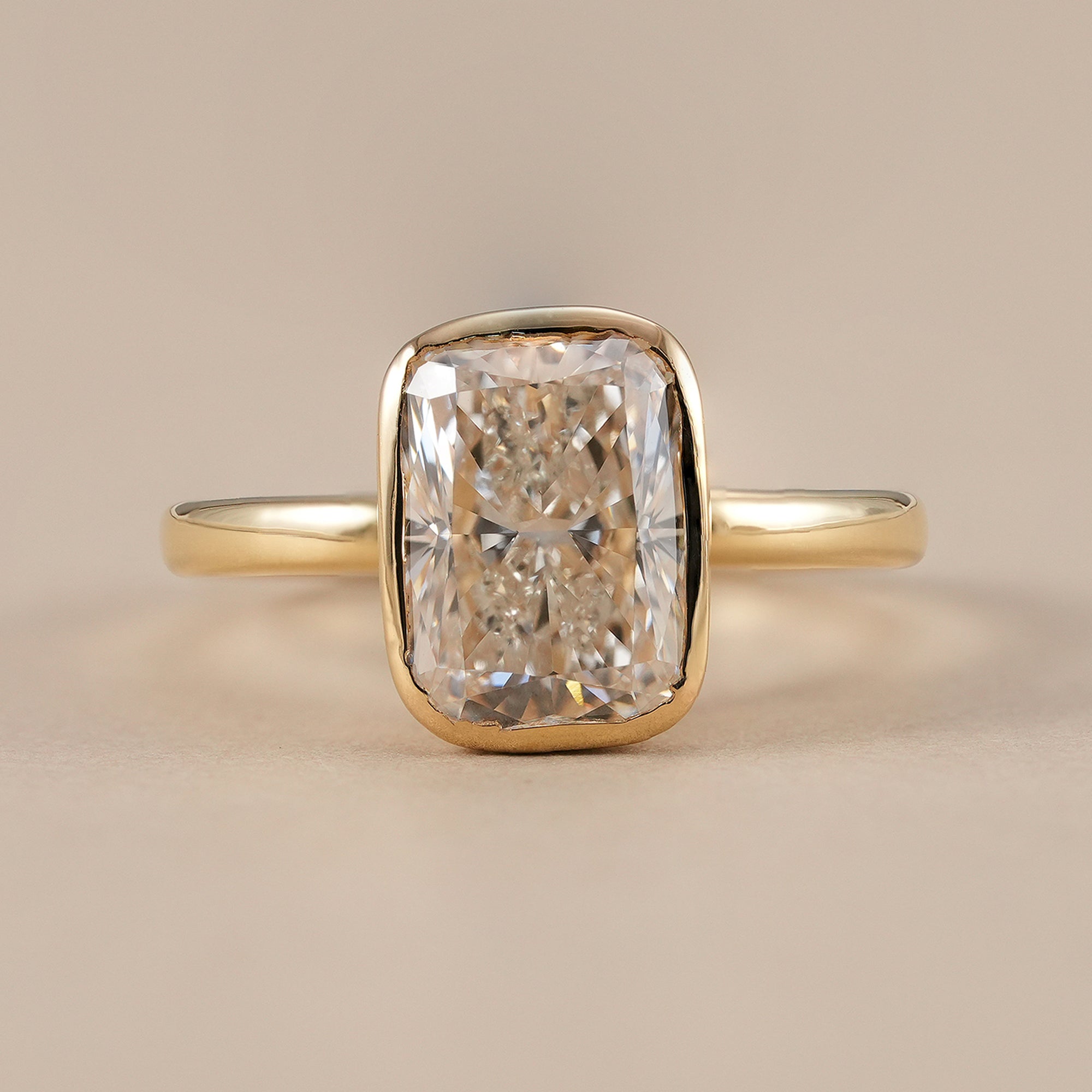 Radiant bezel set lab grown diamond solitaire ring in yellow gold