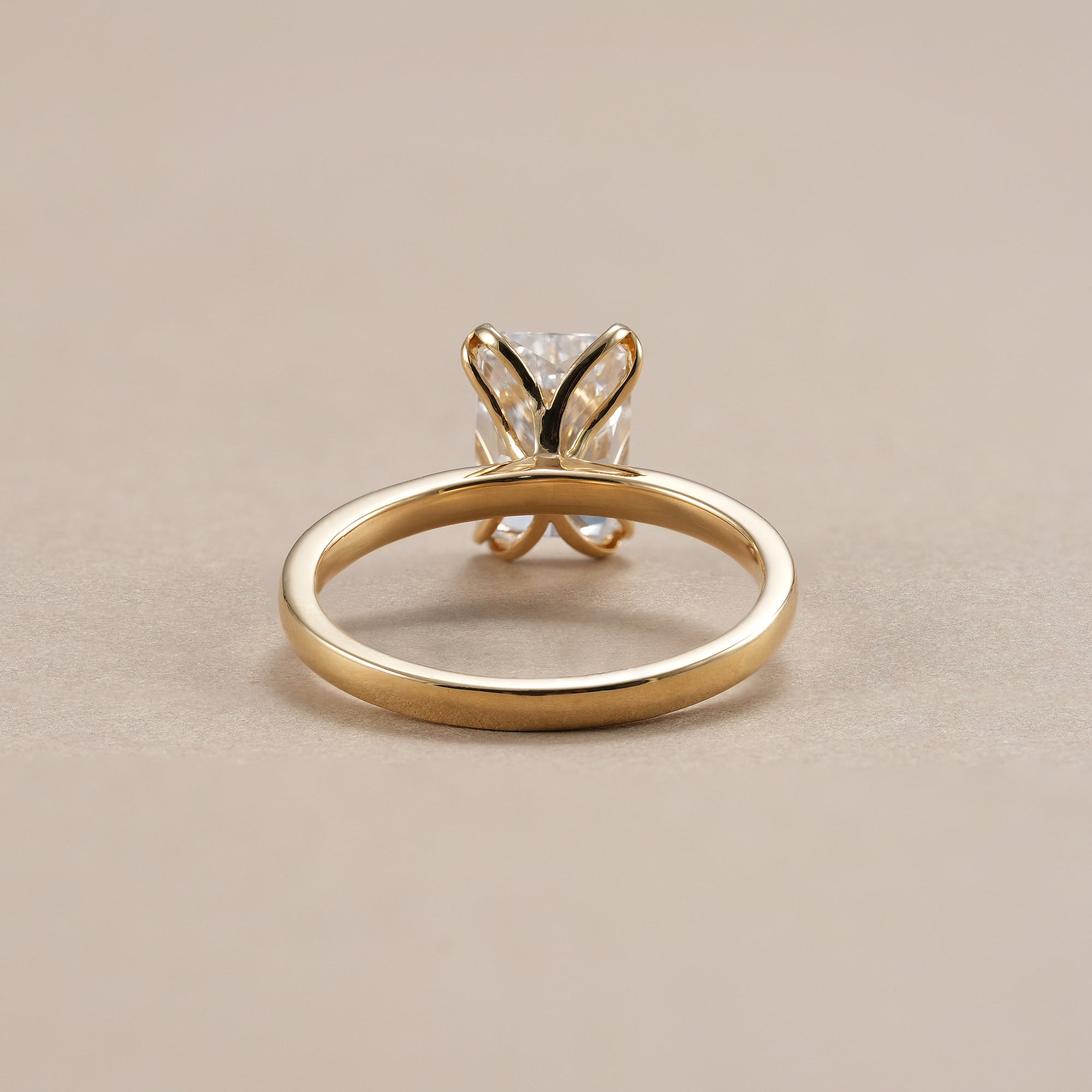 Minimalist radiant diamond solitaire bridal ring with polished gold band.