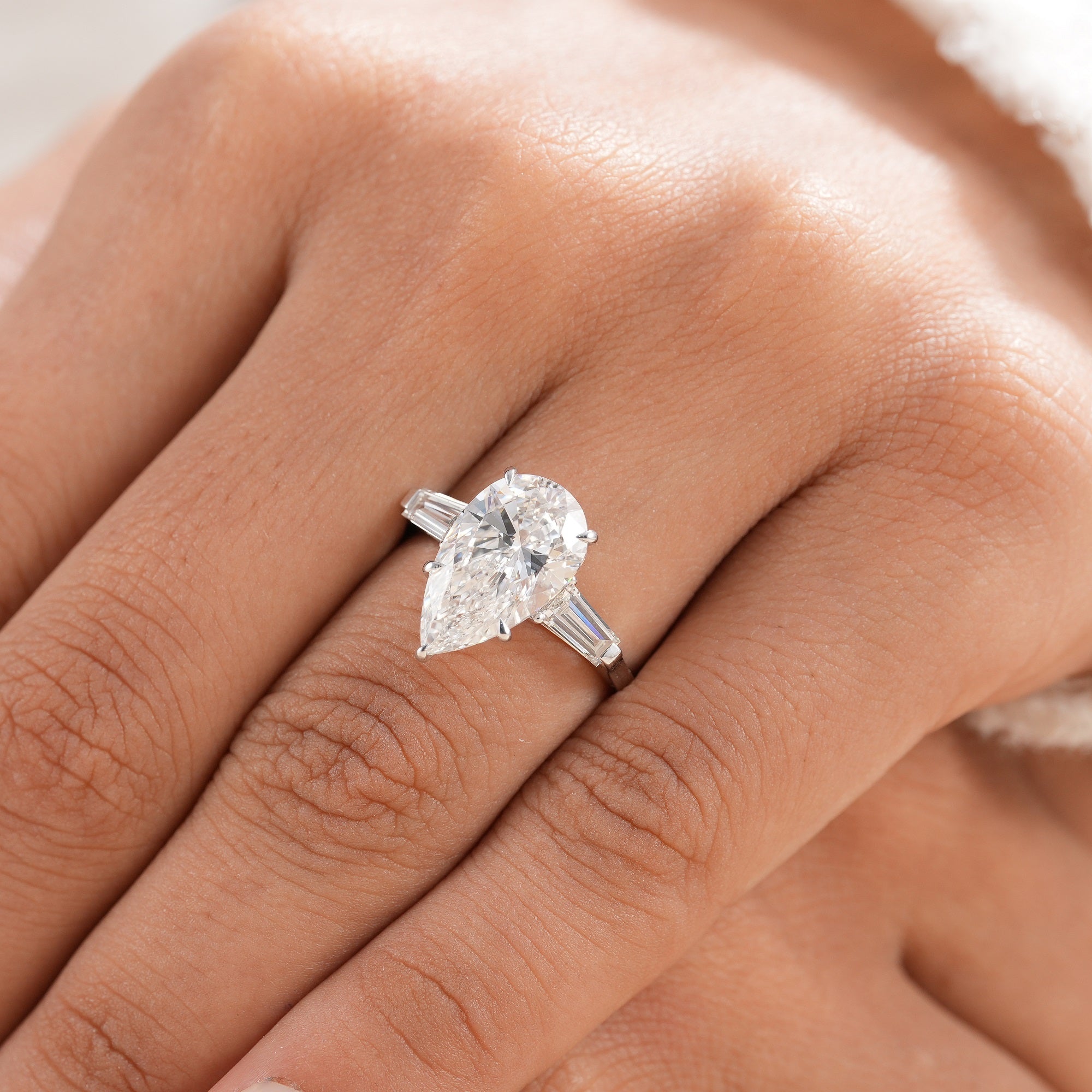 Three stone engagement ring with tapered baguette side diamonds