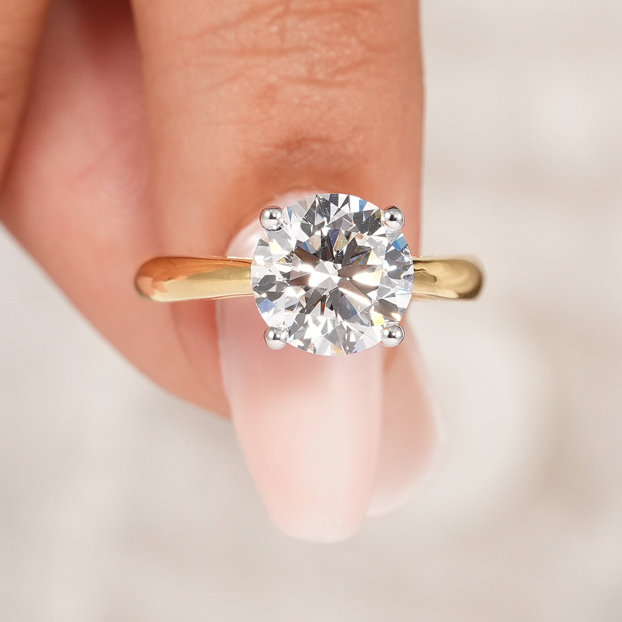 Classic round diamond engagement ring in four prong cathedral setting