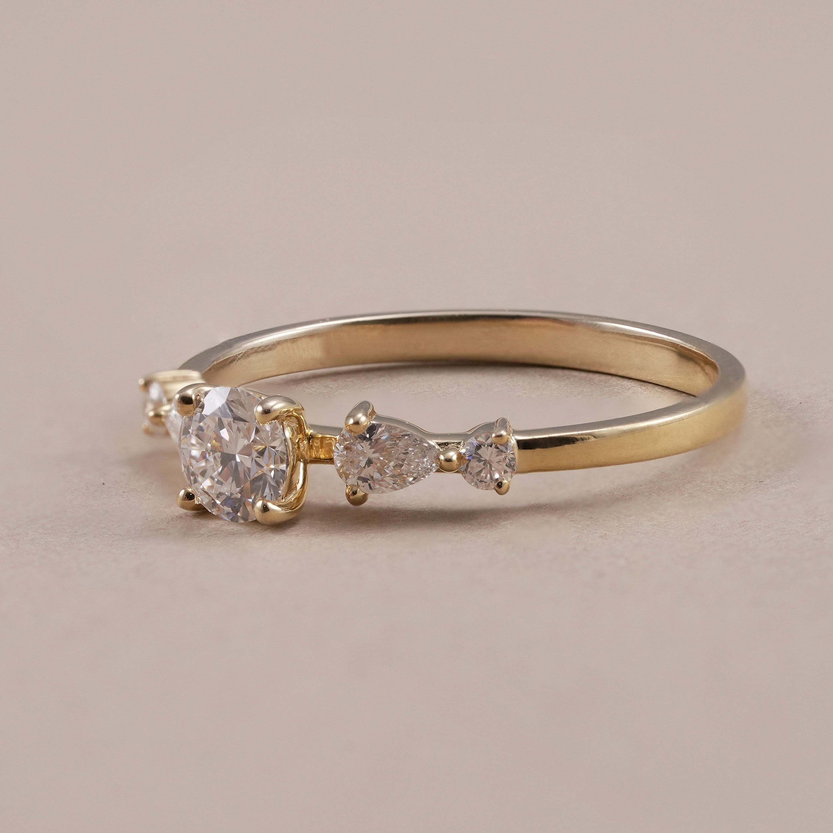 Round diamond engagement ring with pear and round side diamonds
