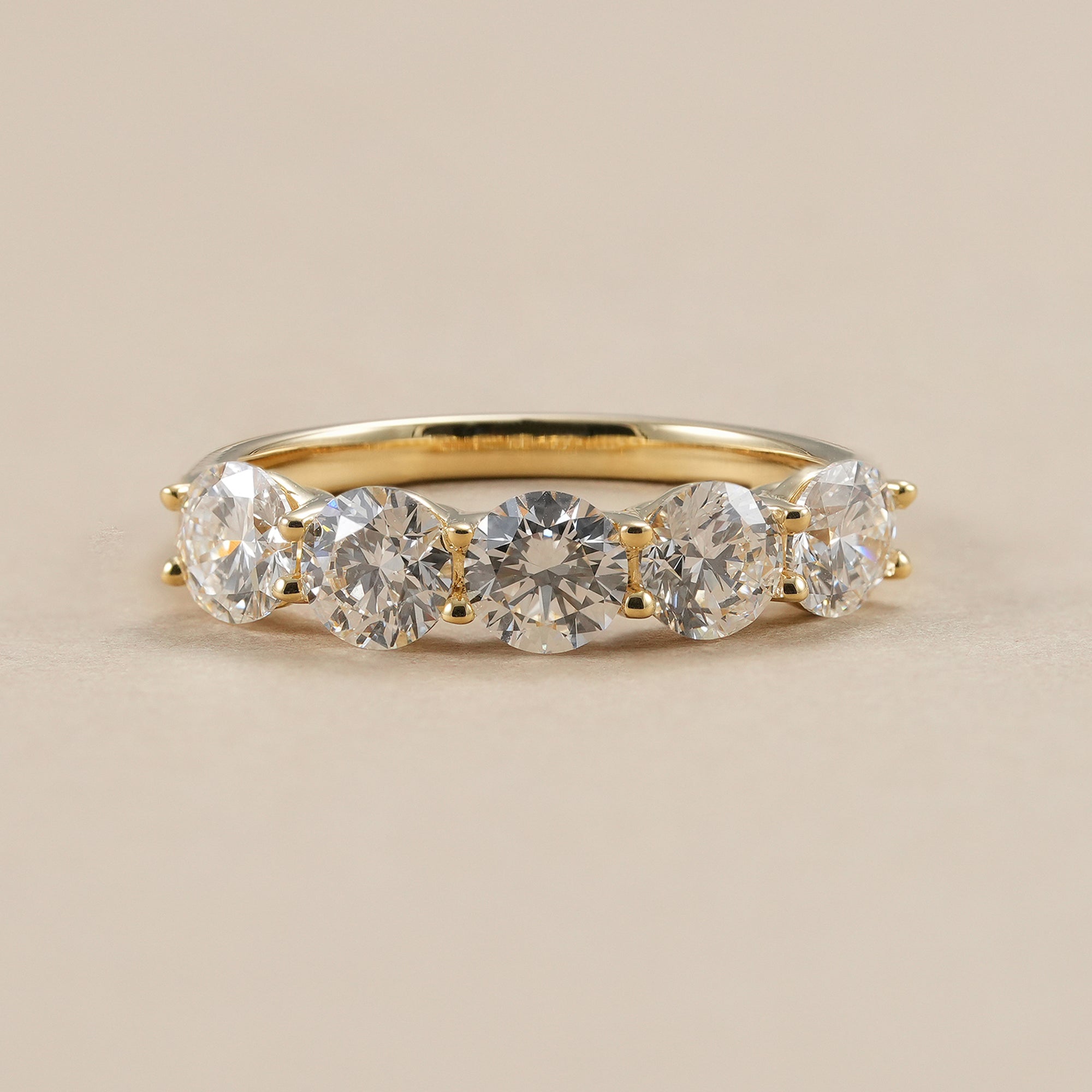 Round diamond wedding band with five lab grown diamonds in yellow gold.